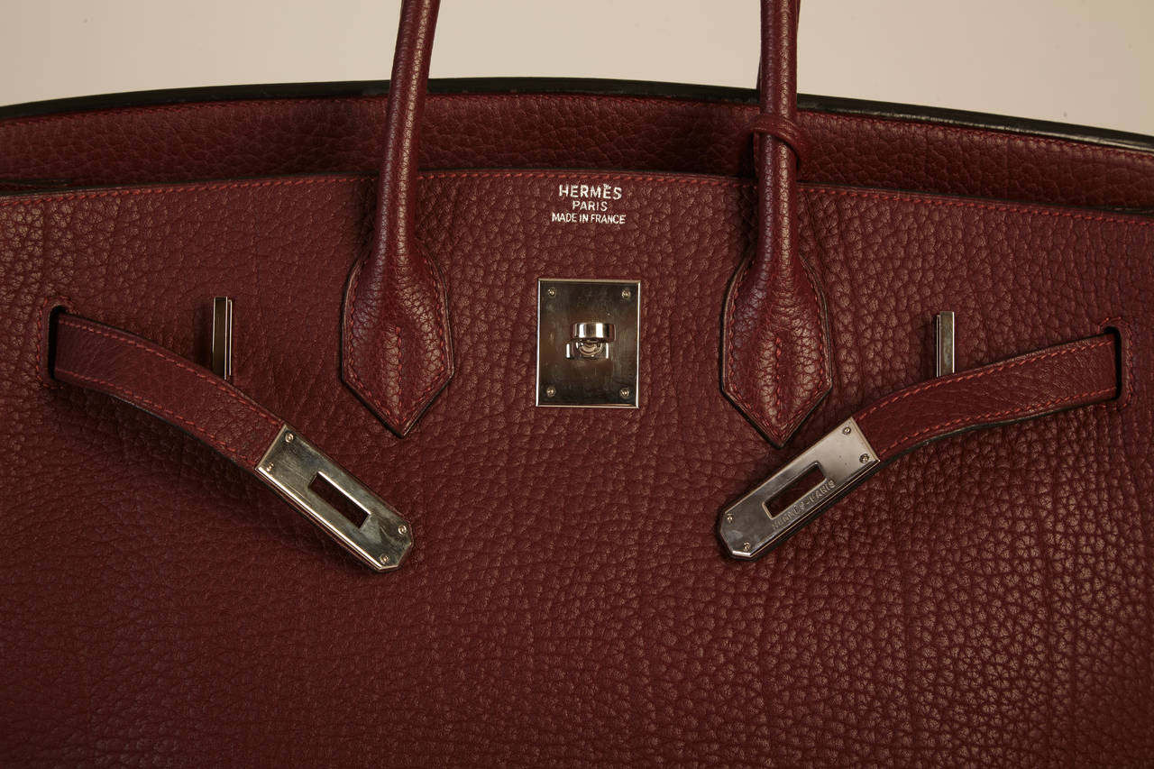 With this magnificent purse draped over your arm, you will look nothing but elegant. Its pristine (used only twice) gorgeous bordeaux anterior consists of rare fjord leather with platinum hardware and 35 cm in size. This color is extremely difficult