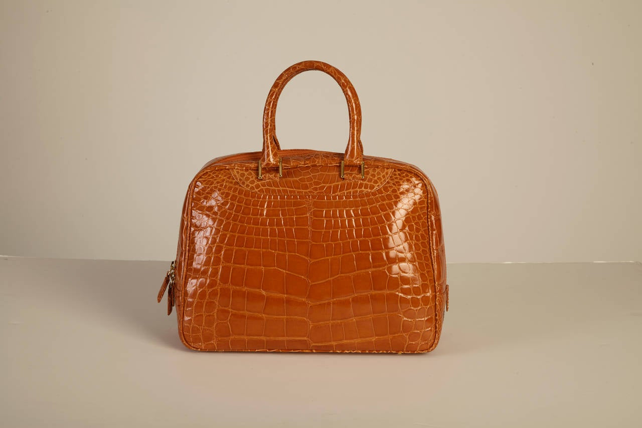 This center cut, alligator purse is the perfect, bright accessory to any outfit, whether it is casual or glamorous. Its deep and spacious interior compartment allows an abundance of room for you to pack all of your essential items needed to conquer