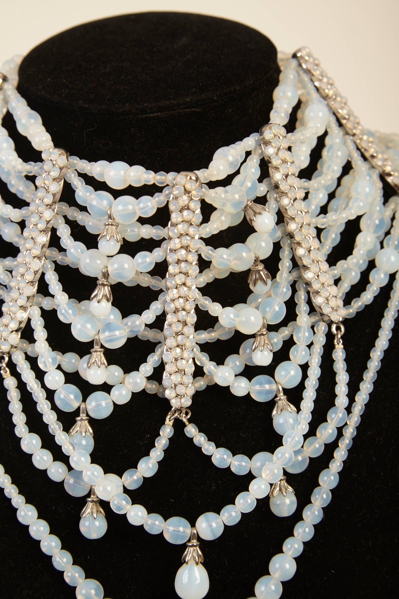 This one of a kind choker necklace contains an incredible array of ivory and aqua beading, which creates an impeccable draped effect. With this magnificent accessory and its timeless elegance, you will be deemed the most stunning and sophisticated