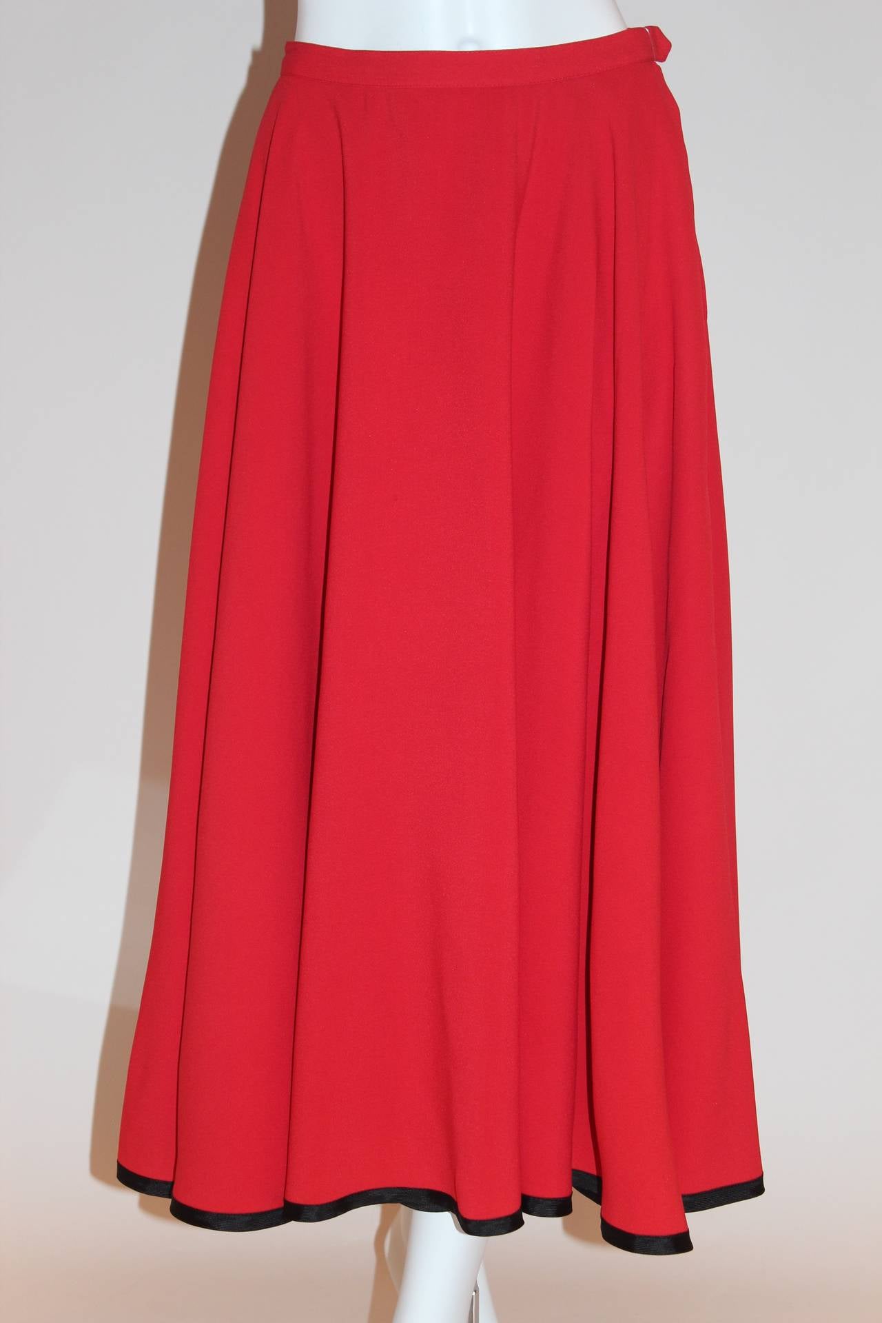 This brilliant red skirt will add a sexy flair to your evening outfit. With its superb, show-stopping color, straight cut, hidden zipper, and black border trim at the bottom, this piece will catch every eye in the room.