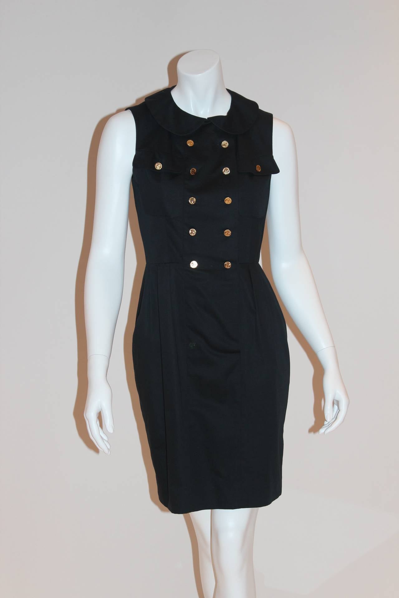 This knee-length navy dress is a classic piece for any casual occasion. Contains a Peter Pan collar, cinched waist, and subtle pleats. Additionally contains two breast pockets that are enclosed with a single gold-tone button. Five pairs of gold-tone