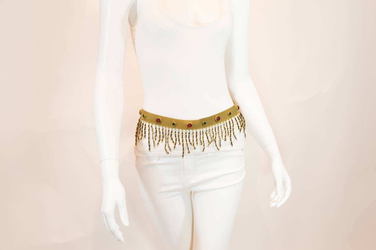 This brilliant, adjustable belt will add a unique sparkle to any outfit.  Finely embossed with precious red and green stones and contains dangling, gold/black braided links throughout. The superior, golden portion of the belt is intricately woven