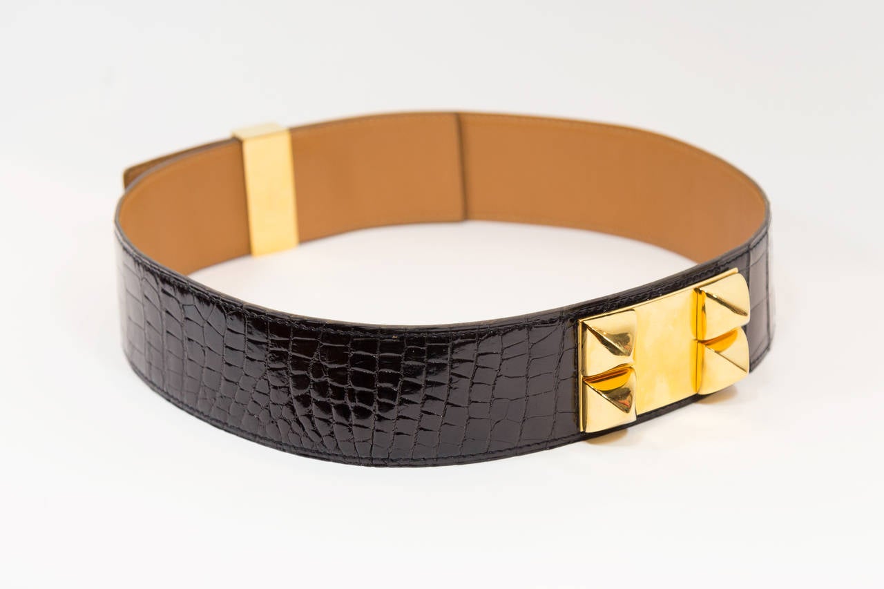 This magnificent crocodile belt contains signature gold, plated Collier de Chien hardware that creates a stunning color combination against its black, glossy exterior. It is a classic, chic, and edgy addition to any outfit. In excellent condition.