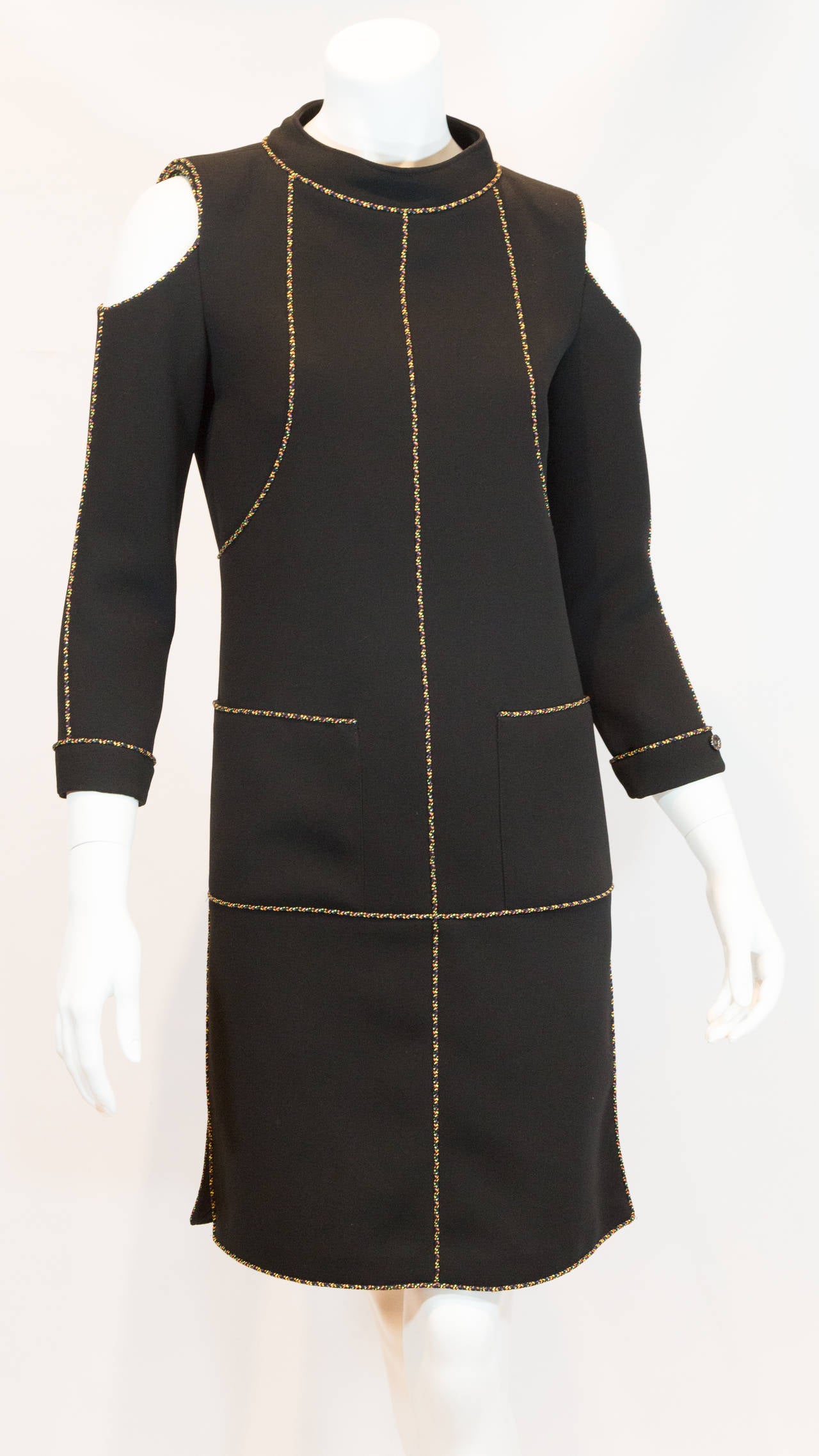 2014 Chanel open shoulder black dress with multicolor trim. Two front pockets and one slit on each side of the dress. Buttons with double C logo on the bottom of each sleeve. From the Spring 2014 Collection with original tags.