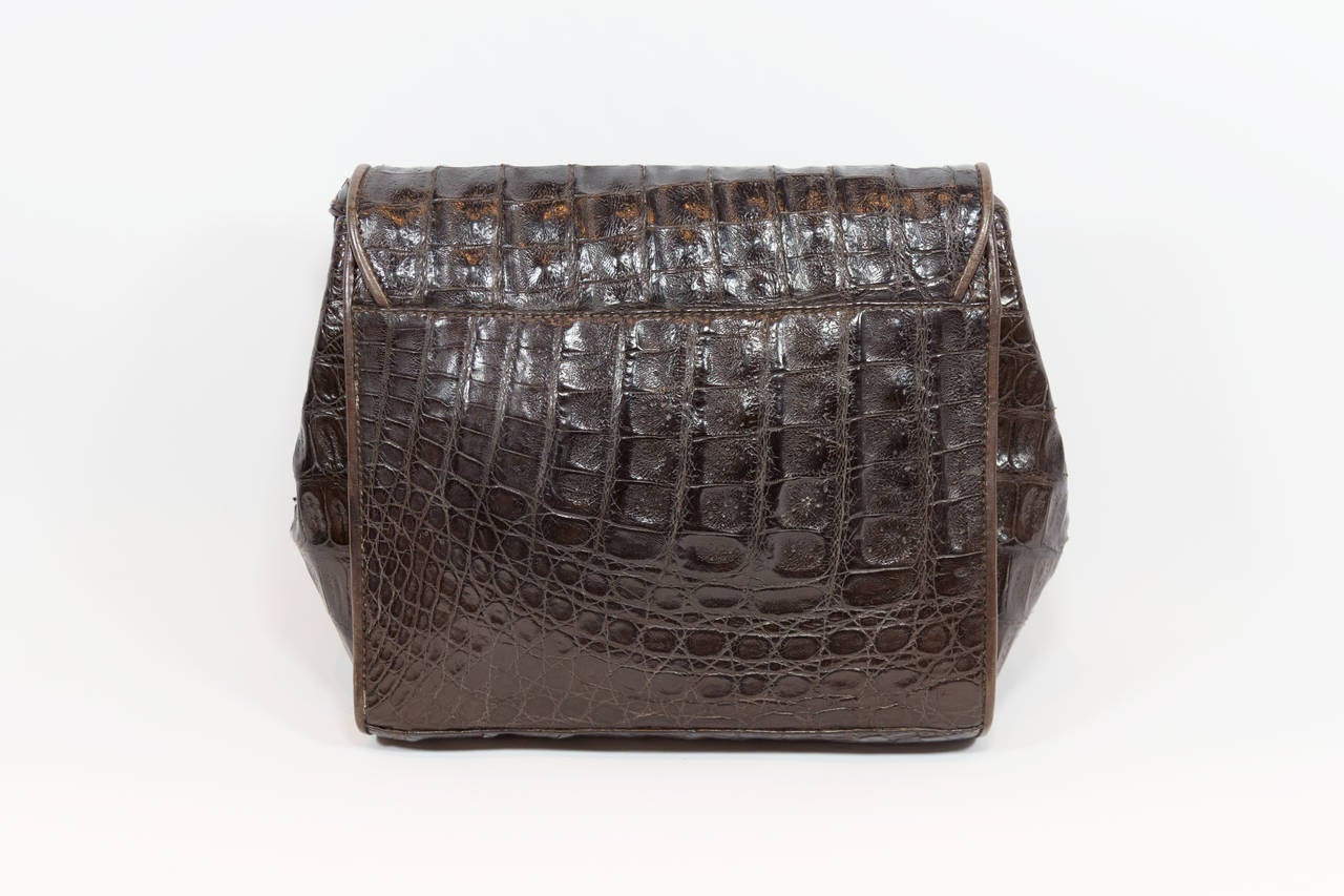 Exquisite vintage chocolate brown crocodile handbag by Donna Karan. Shoulder strap is in two pieces and is tied together with a knot so that it is adjustable. Interior is stamped with Donna Karan New York logo and has a large center compartment that