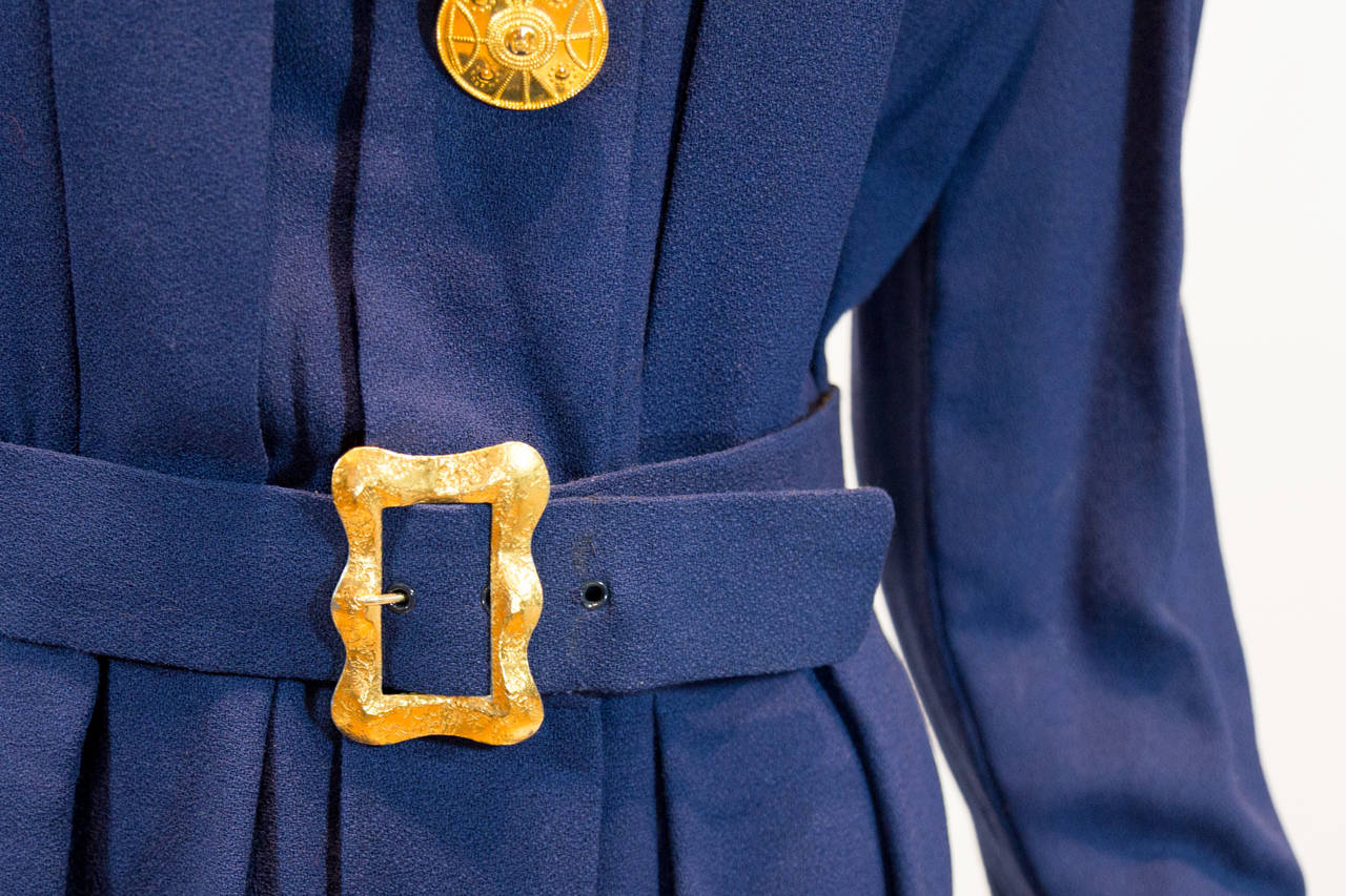 Chanel vintage blue dress detailed with four large gold buttons with the double C logo on the front of the dress and one button at the bottom of each sleeve. Waist is detailed with gold belt buckle.