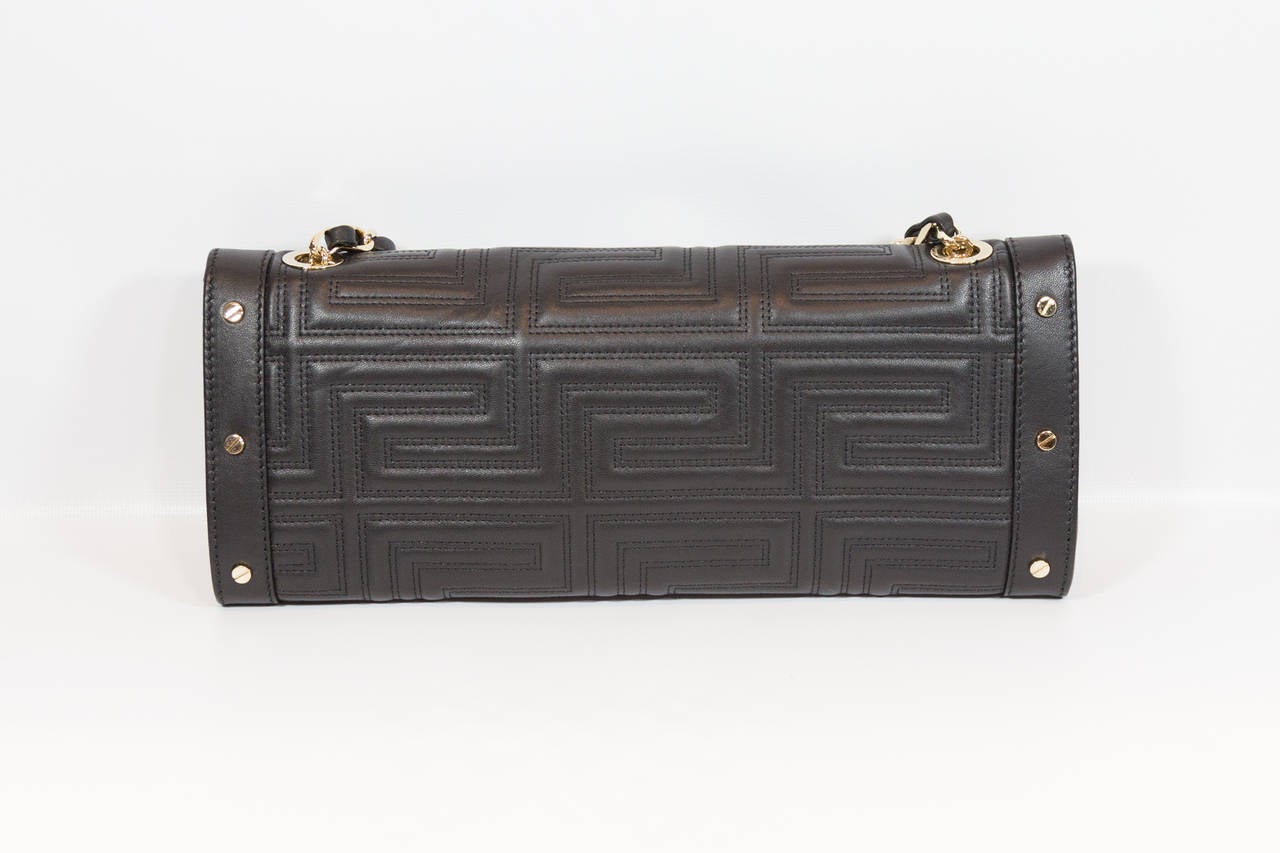 Gianni Versace black quilted patent leather clutch with gold chain in excellent condition.