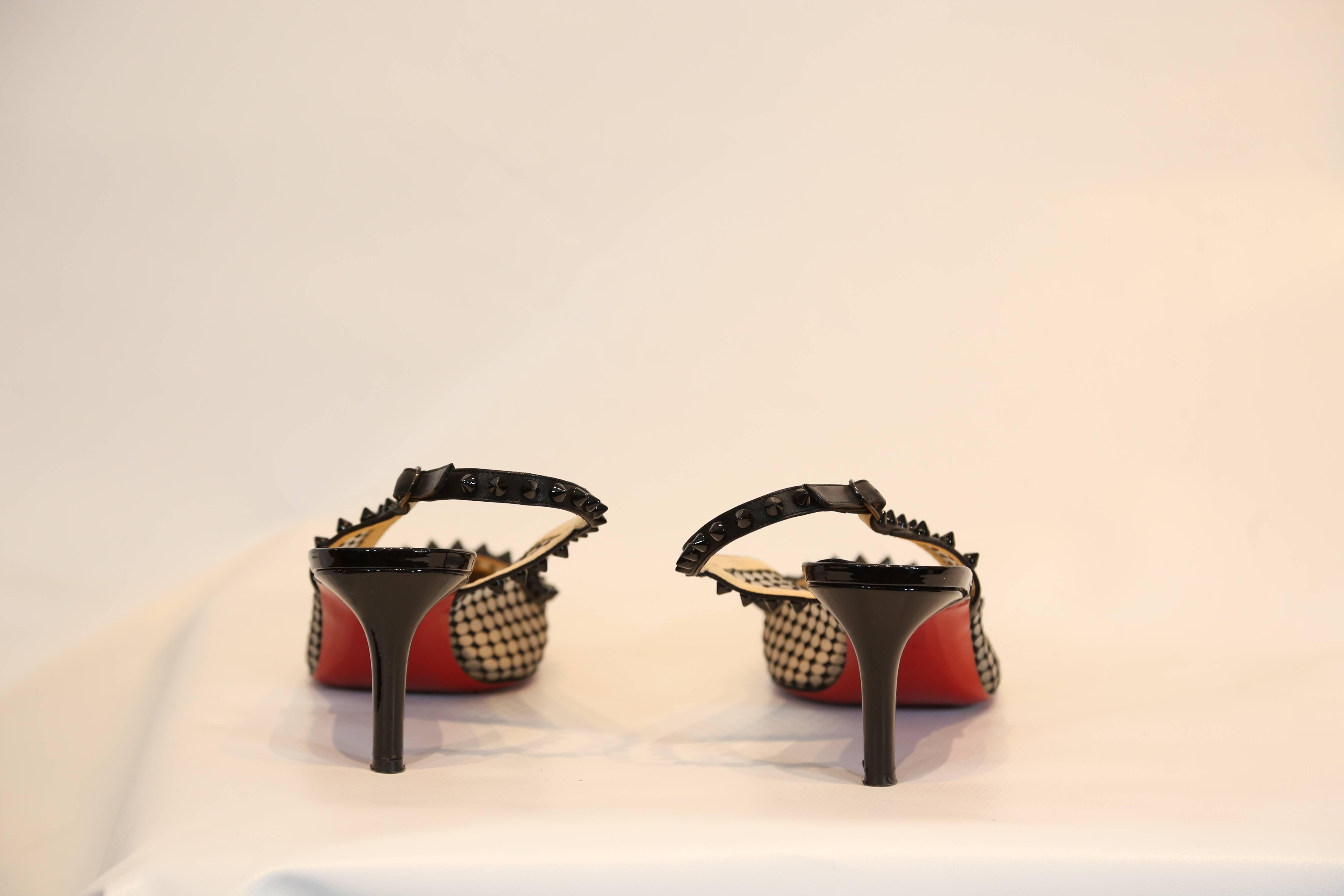 Christian Louboutin black kitten heel slingback with studded toe and mesh detail. 