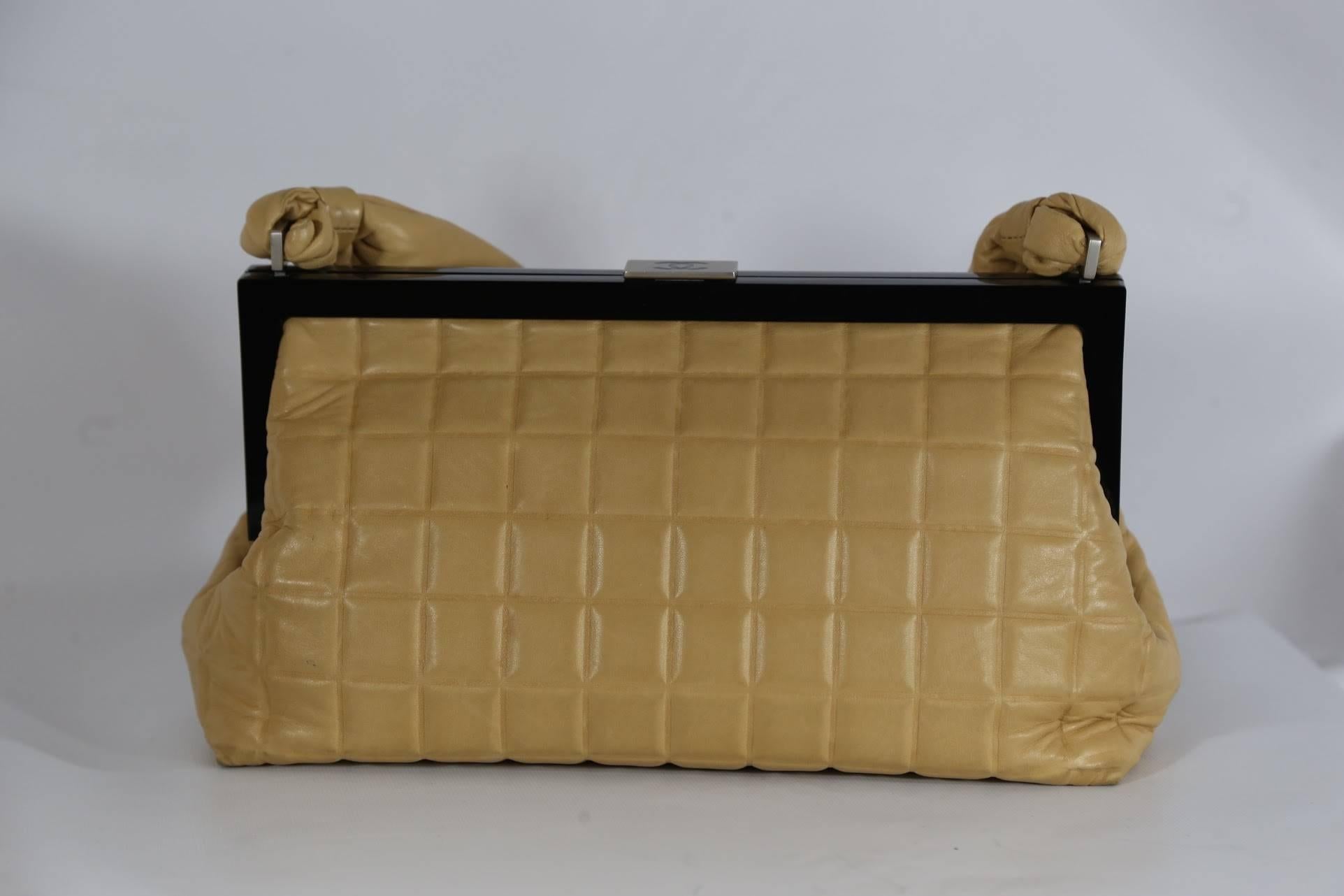 Chanel beige quilted handbag with black trim and silver logo enclosure. 