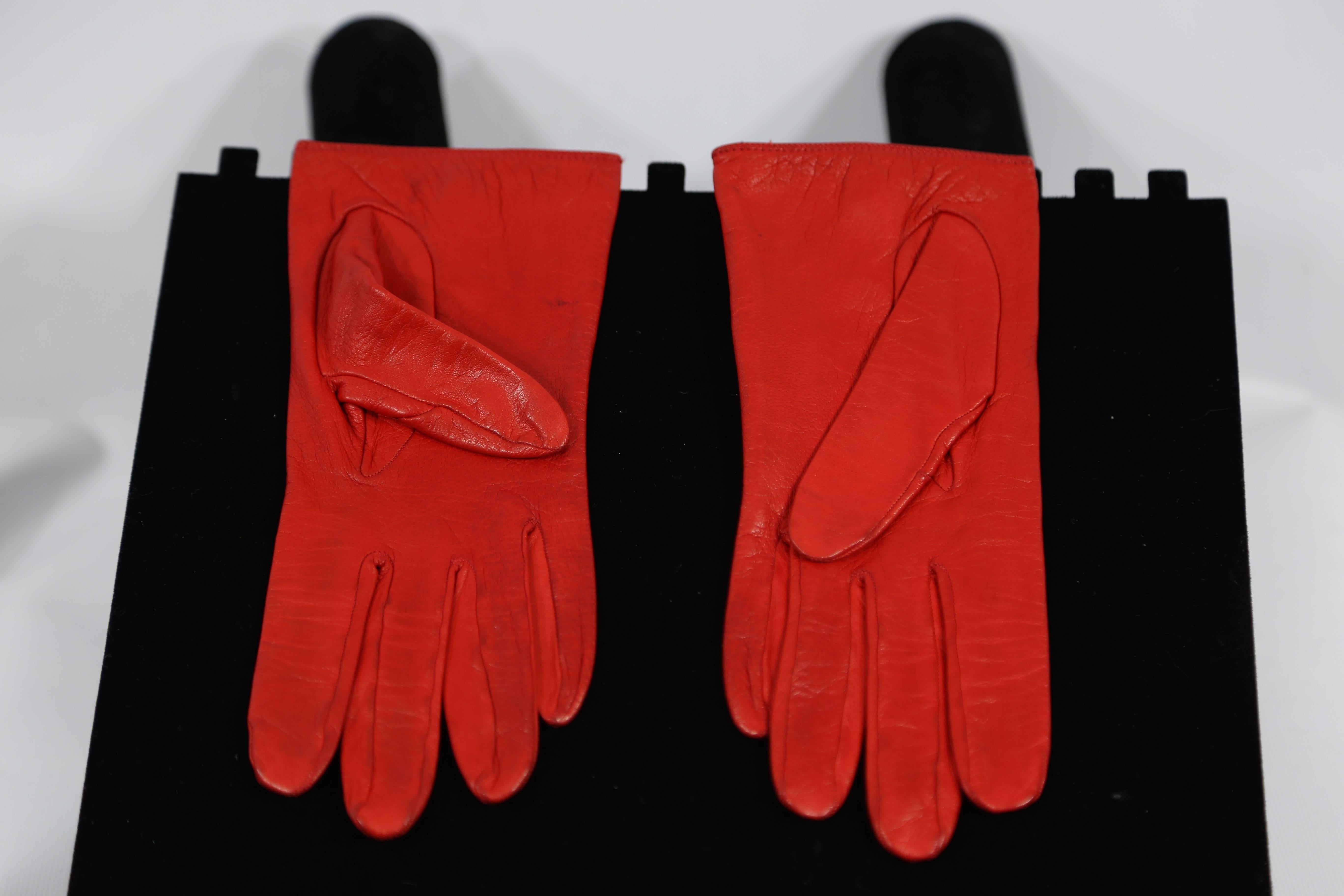 Chanel red leather gloves with gold button toggle enclosure. 