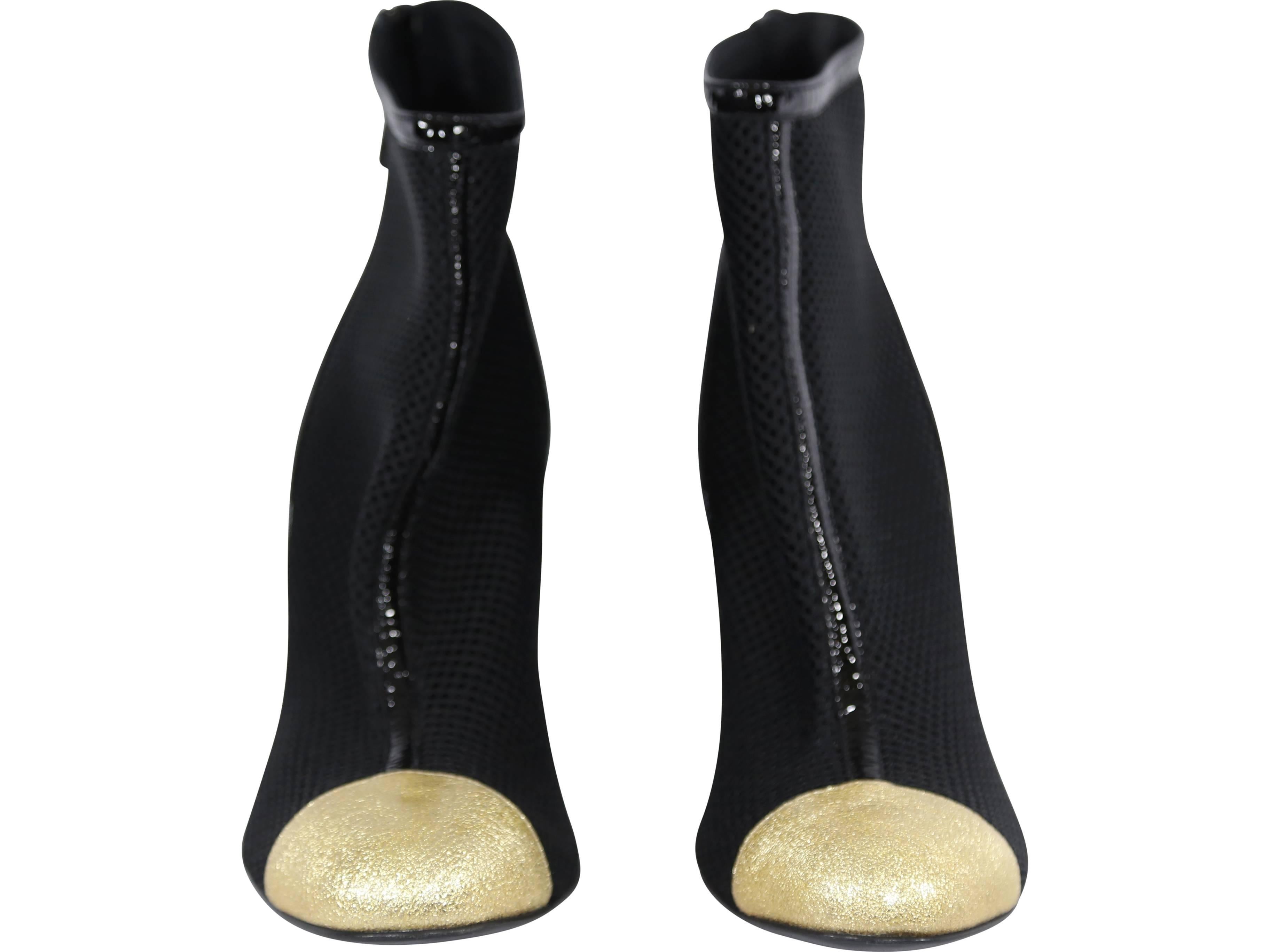 Chanel black patent leather ankle bootie with gold toe cap. 
