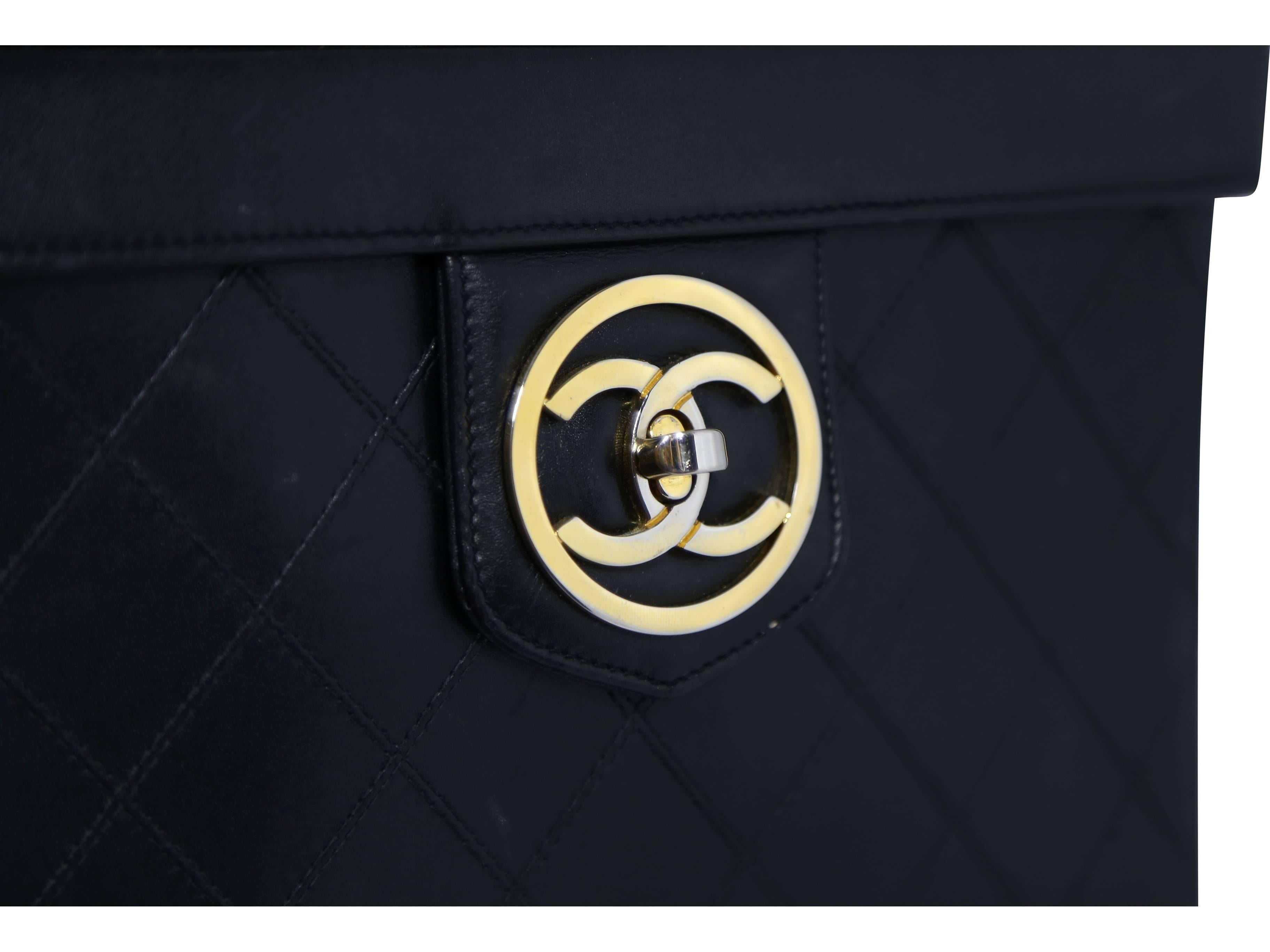 Chanel black leather trunk case with gold CC logo on front. 