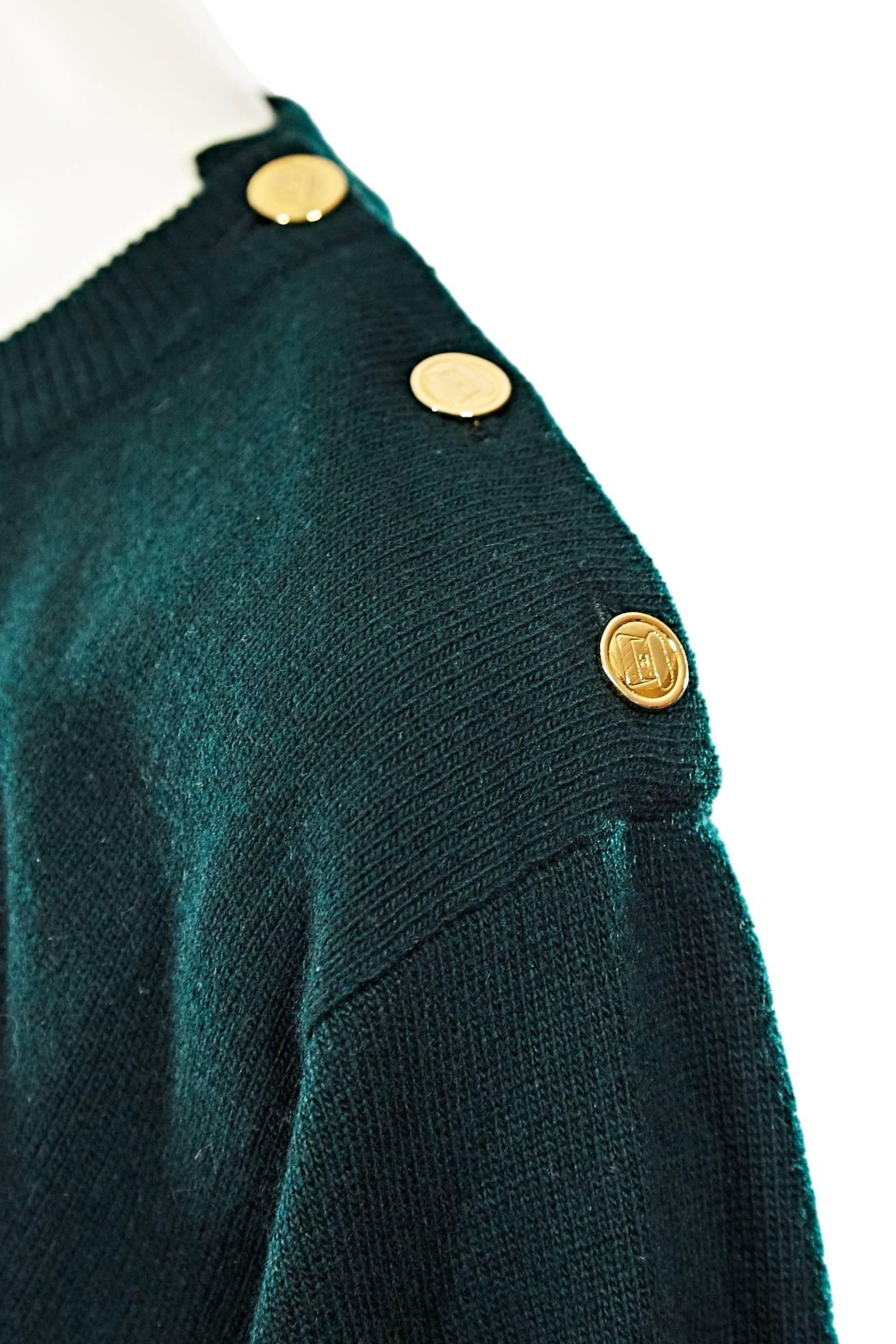 Chanel green and grey cashmere sweater accented with three goldtone buttons.  Long dolman sleeves. Ribbed crewneck, cuffs and hem. Pullover style.