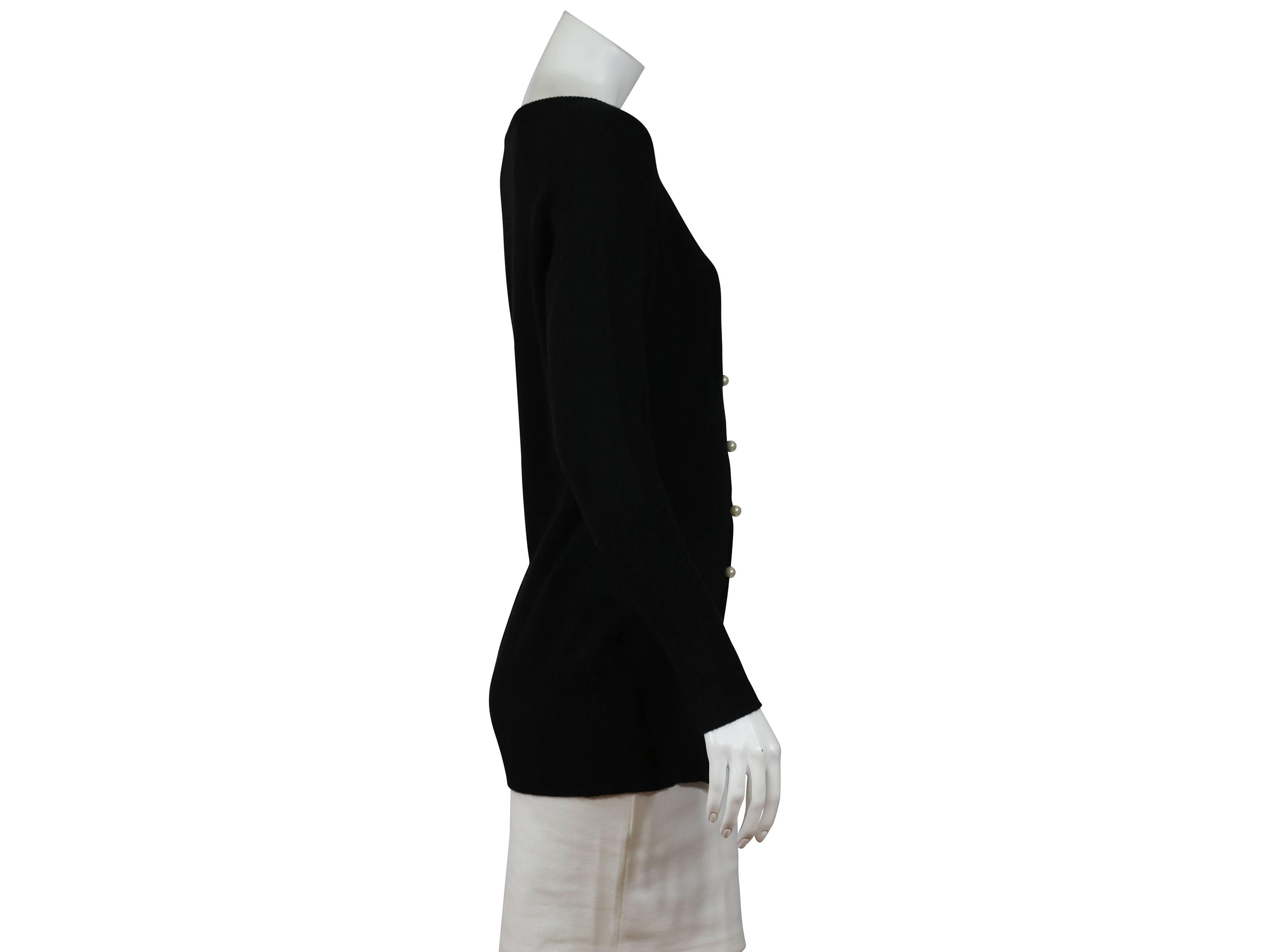 Black cashmere Chanel cardigan in a long silhouette.  Ribbed scoopneck. Pearl button-front closure.