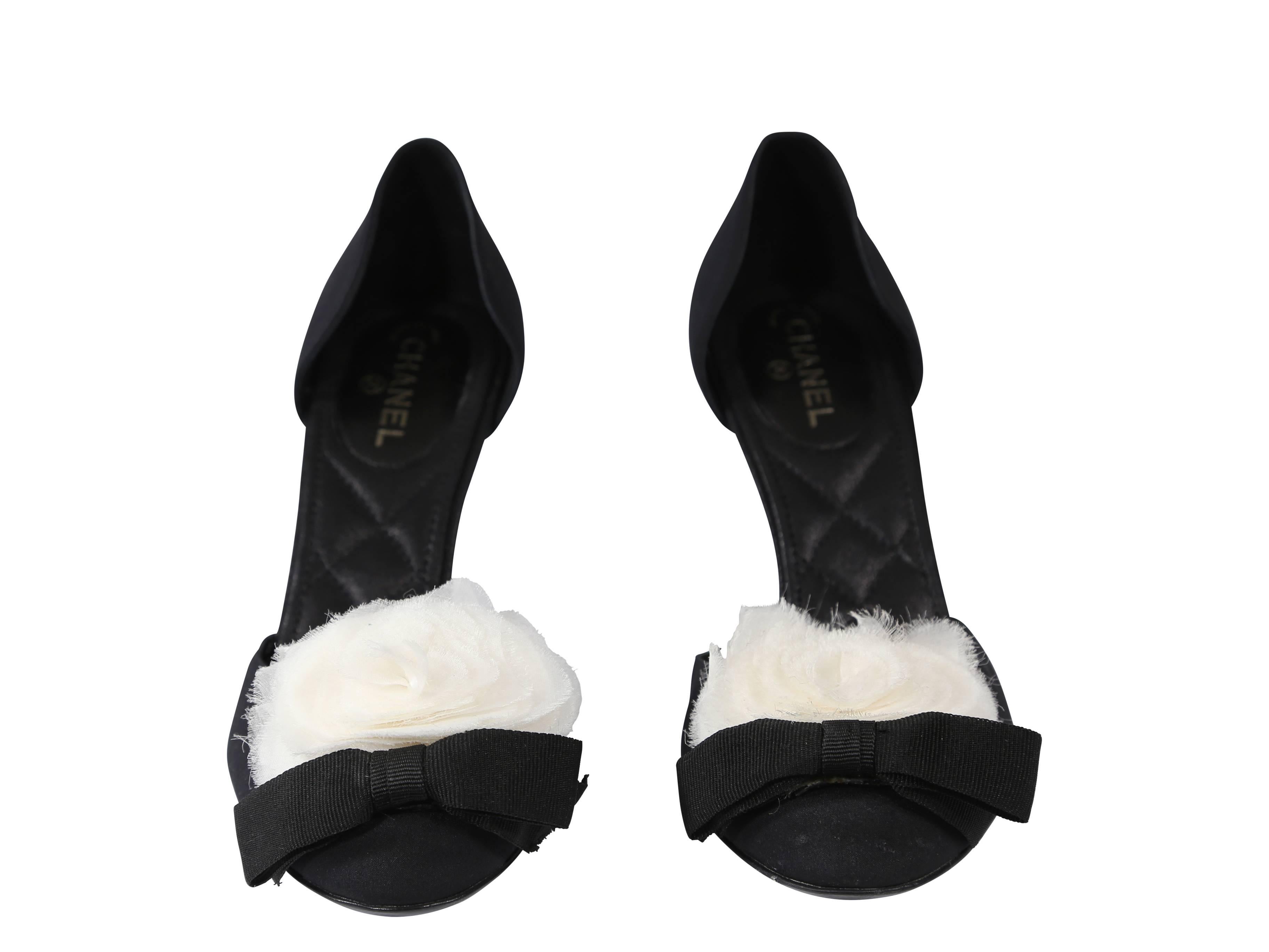 Black Chanel d'Orsay pumps.  White floral applique and black grosgrain ribbon accent round toe.  Slip-on style.