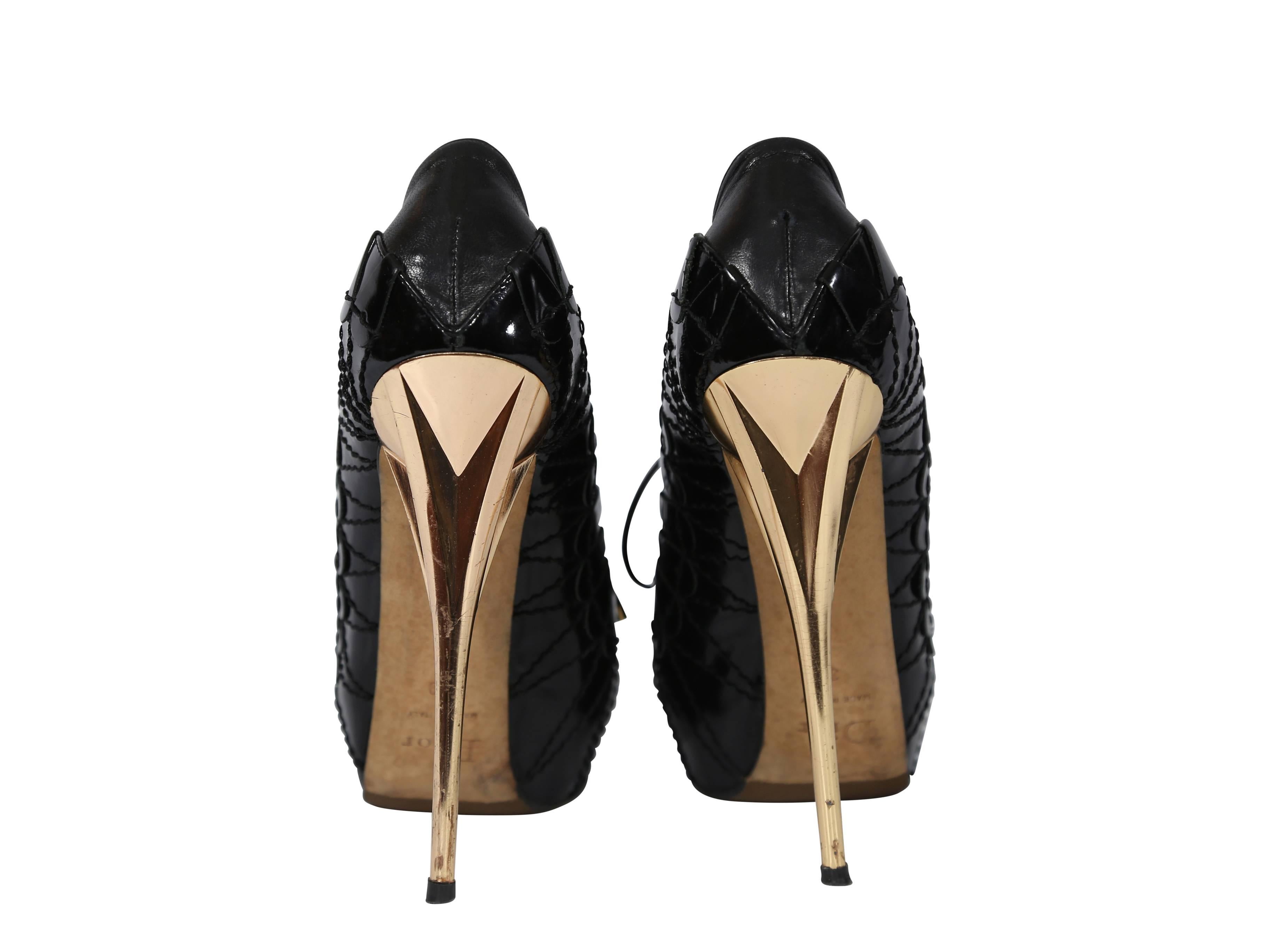Black leather Christian Dior pumps accented with patent leather and tonal topstitching.  Metallic stiletto heel and covered platform.  Lace-front closure.