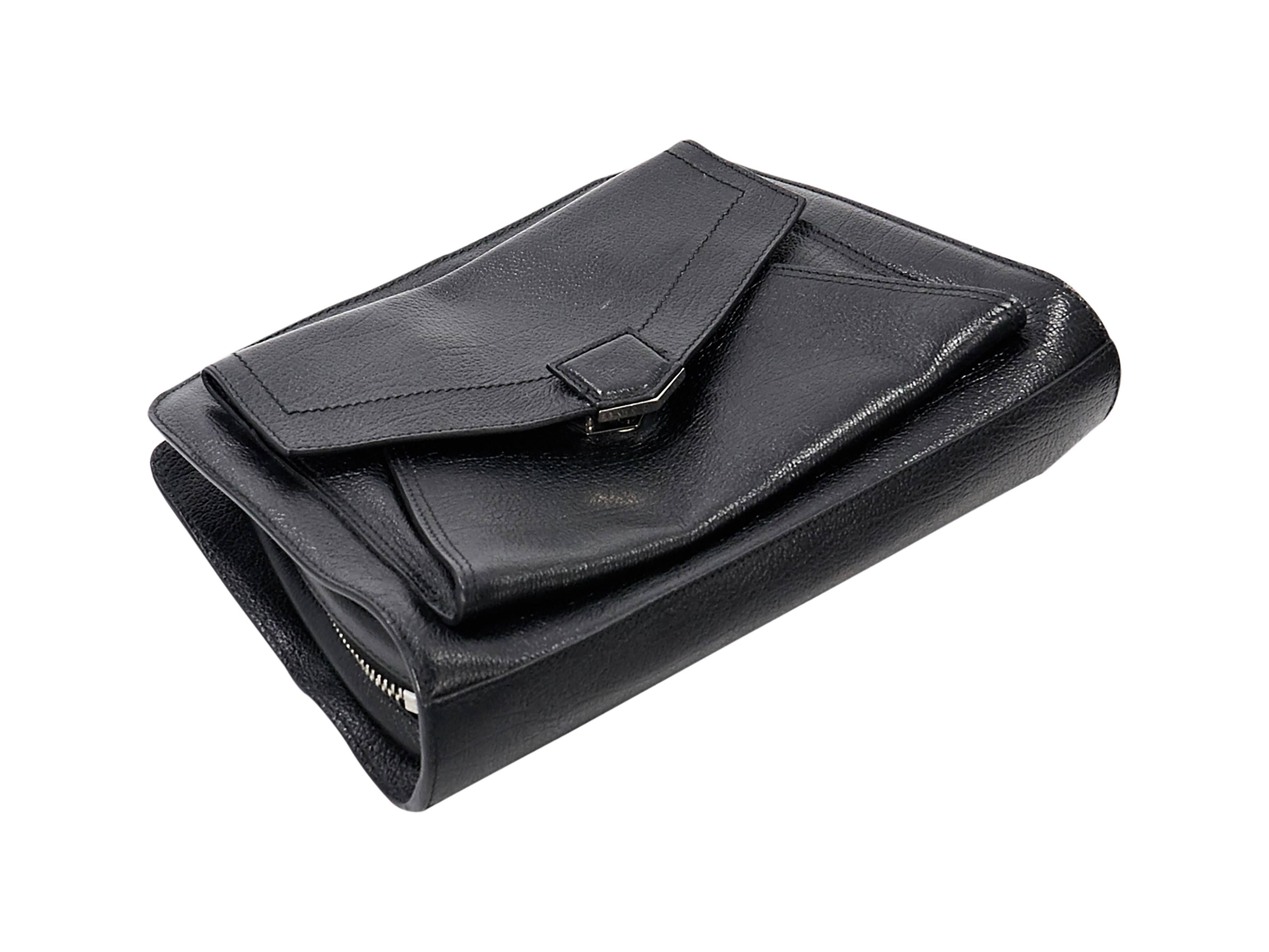 Product details: Black leather PS13 clutch by Proenza Schouler. Top zip closure. Front flap pocket. Lined interior with inner zip pocket. Back exterior zip pocket. Silvertone hardware. 11