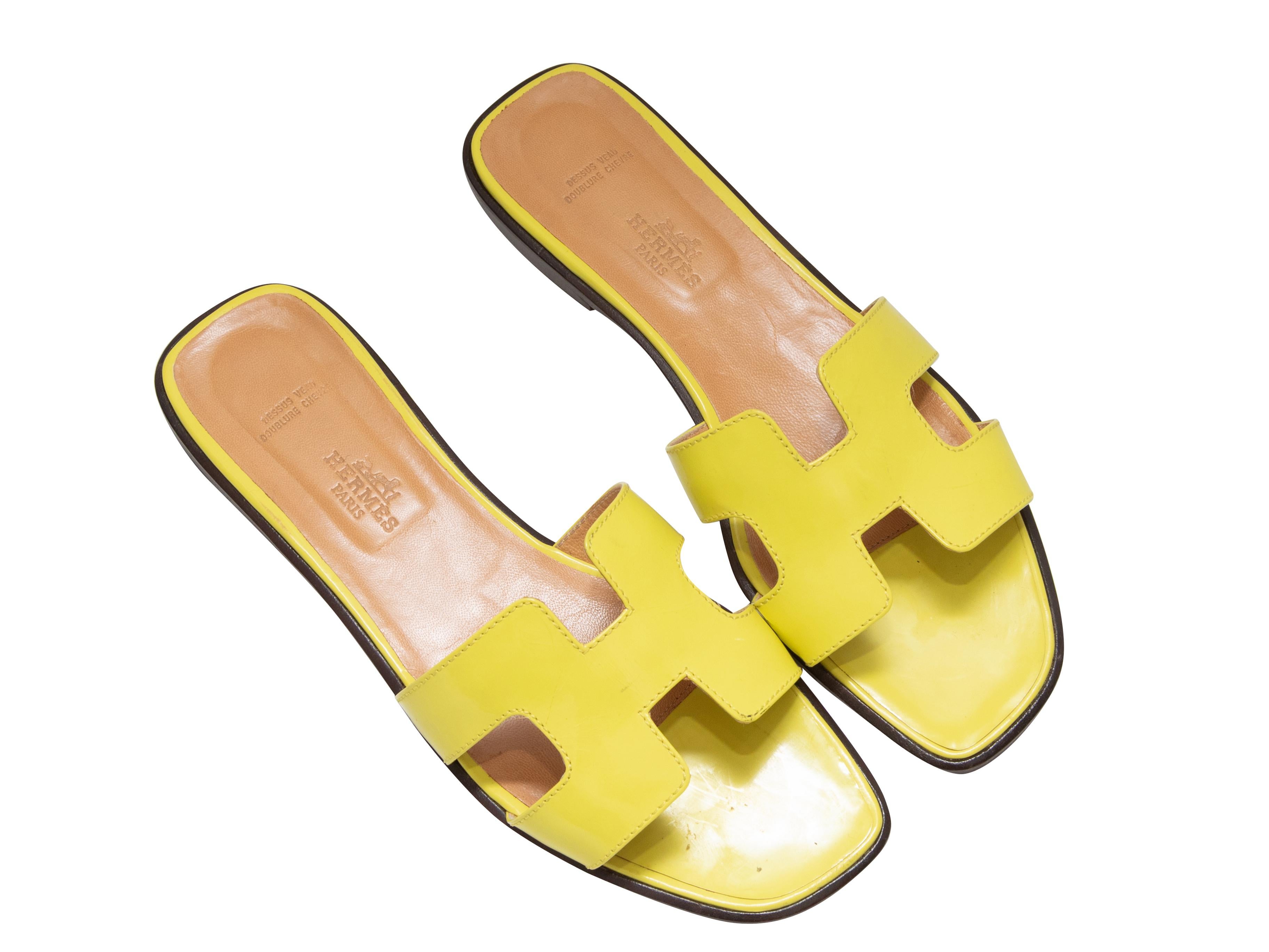 Sandales plates en cuir jaune de la marque Hermès. Hauteur du talon de 0,5