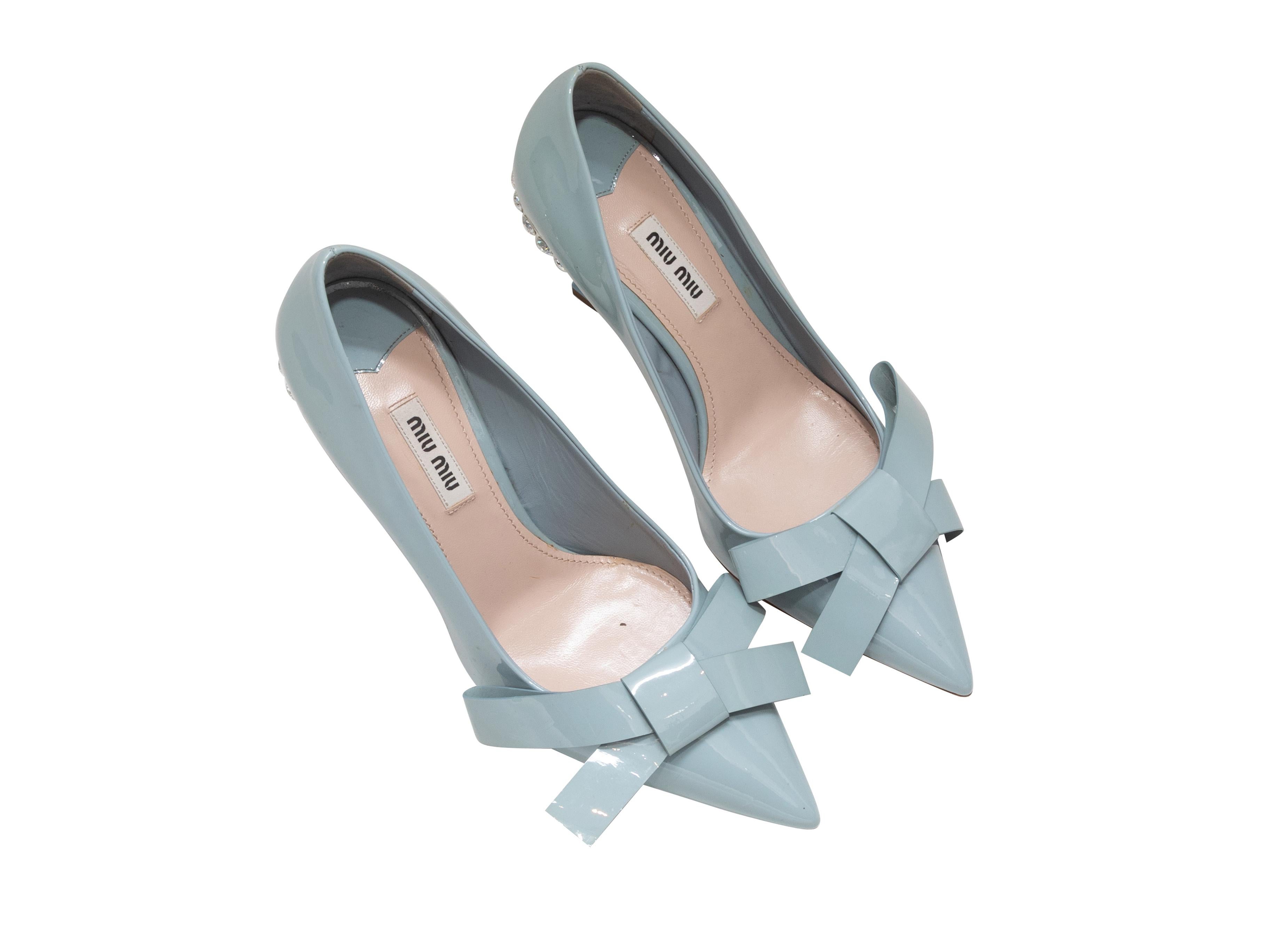 Light blue patent leather pointed-toe crystal and bow-embellished pumps by Miu Miu. 3.75