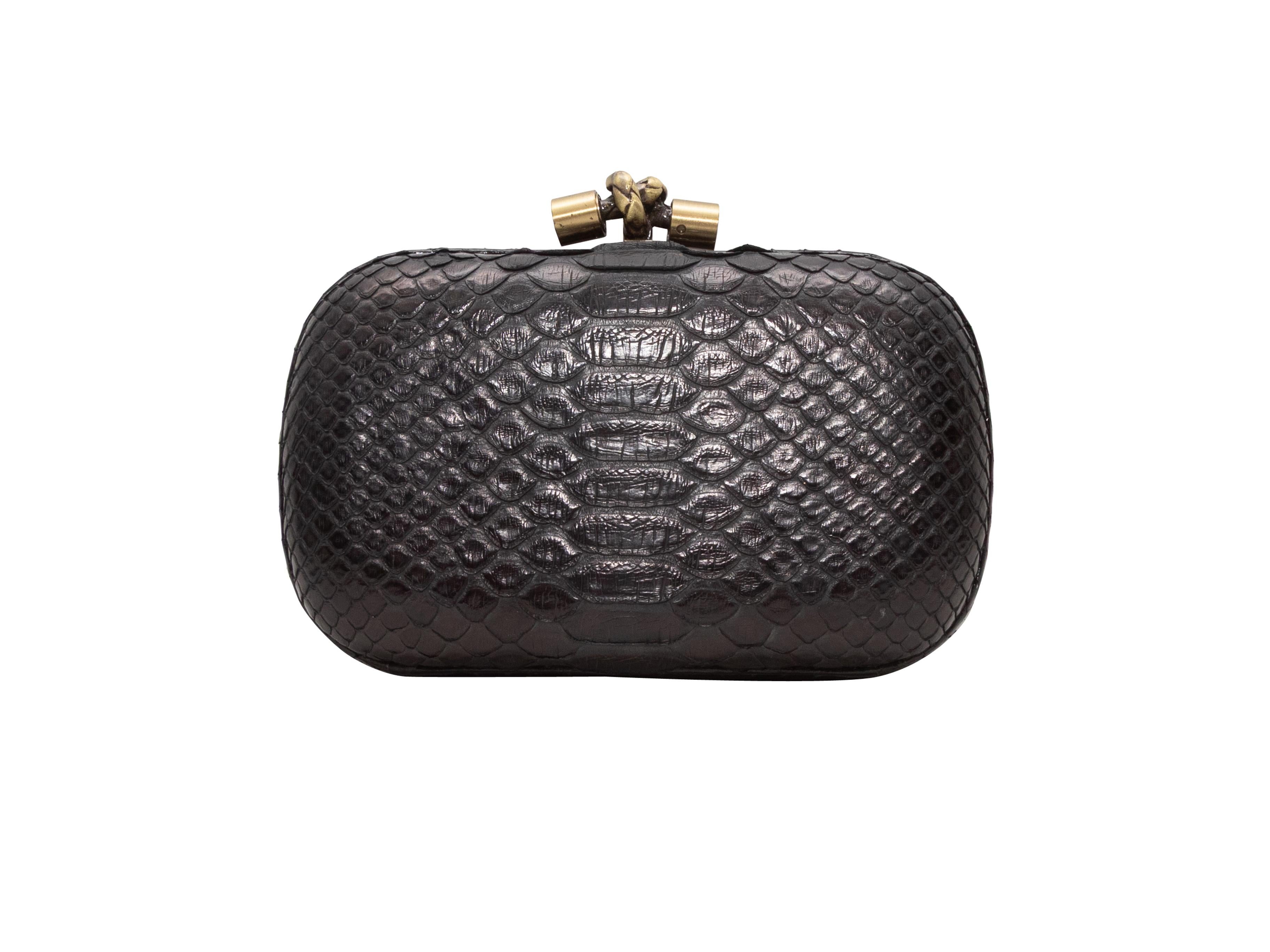 Black Bottega Veneta Small Python Hard Shell Clutch. This clutch features a python skin body, gold-tone hardware, suede interior, and top clasp closure. 7