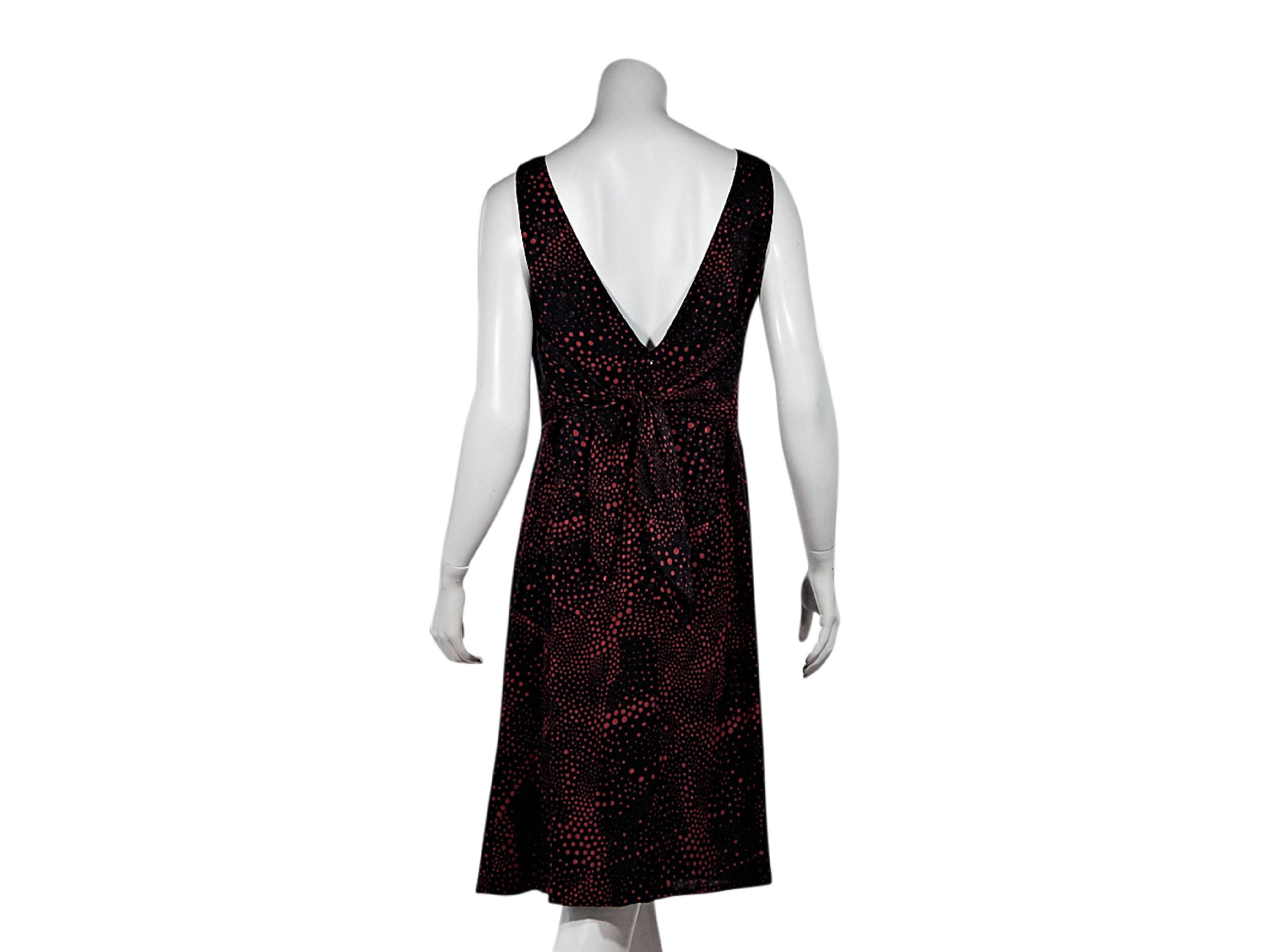 Product details: Black and red dot-printed dress by Escada. Boatneck. Sleeveless. V-back. Concealed back zip closure. Tie-back accent. 
Condition: Pre-owned. Very good.
Est. Retail: $ 698.00