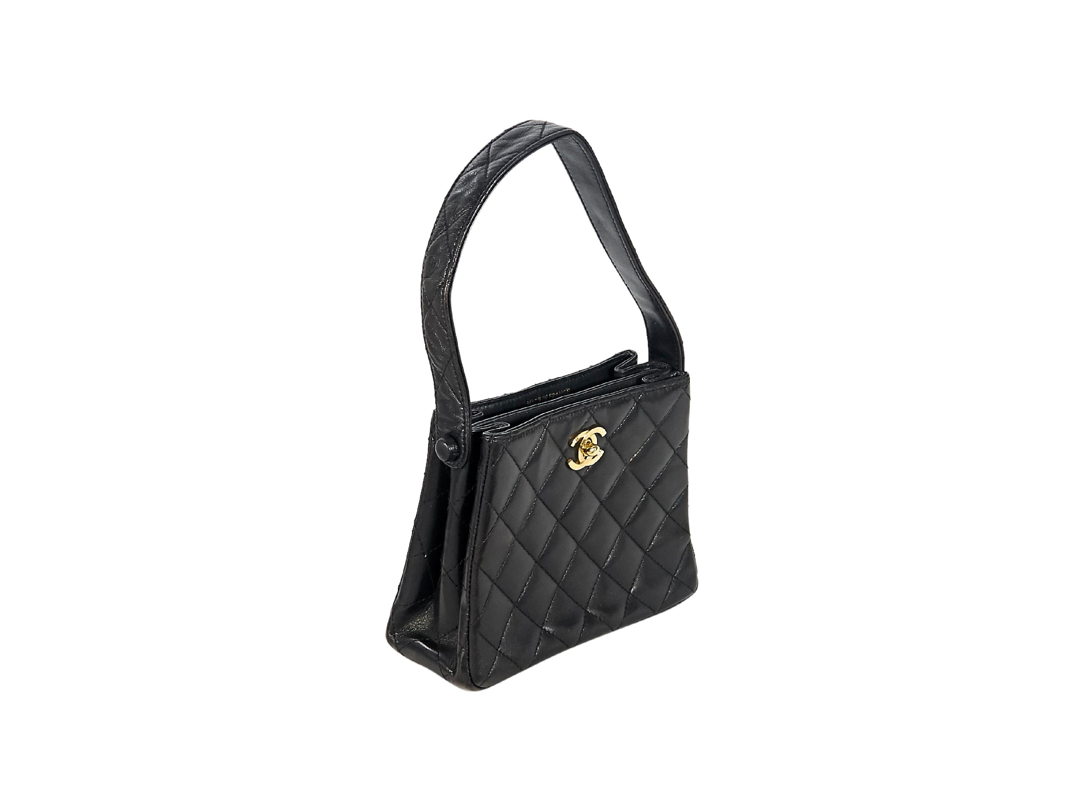 Product details:  Black quilted lambskin leather mini evening bag by Chanel.  Single shoulder strap.  Top twist-lock closure.  Leather interior with two compartments.  Goldtone hardware.  Authenticity card included.  6.5