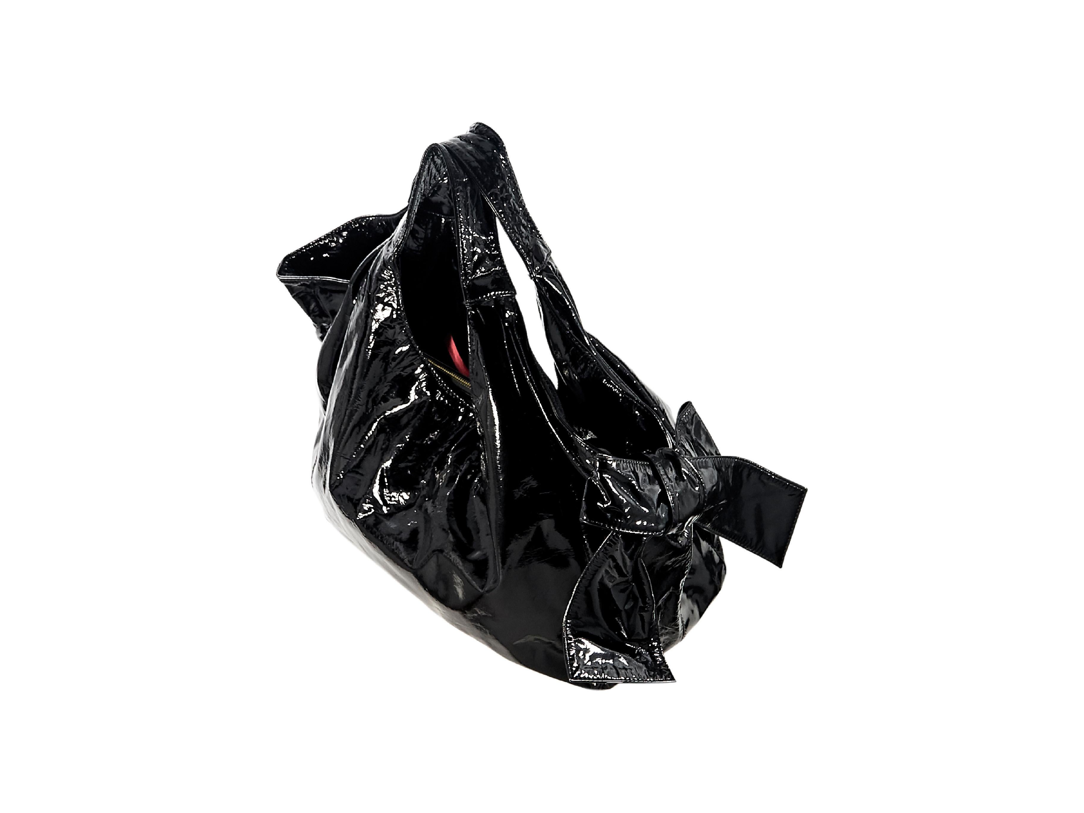 Product details:  Black patent leather Nuage Bow shoulder bag by Valentino.  Dual shoulder straps.  Open top.  Lined interior with inner center zip compartment and inner zip pocket.  Goldtone hardware.  19