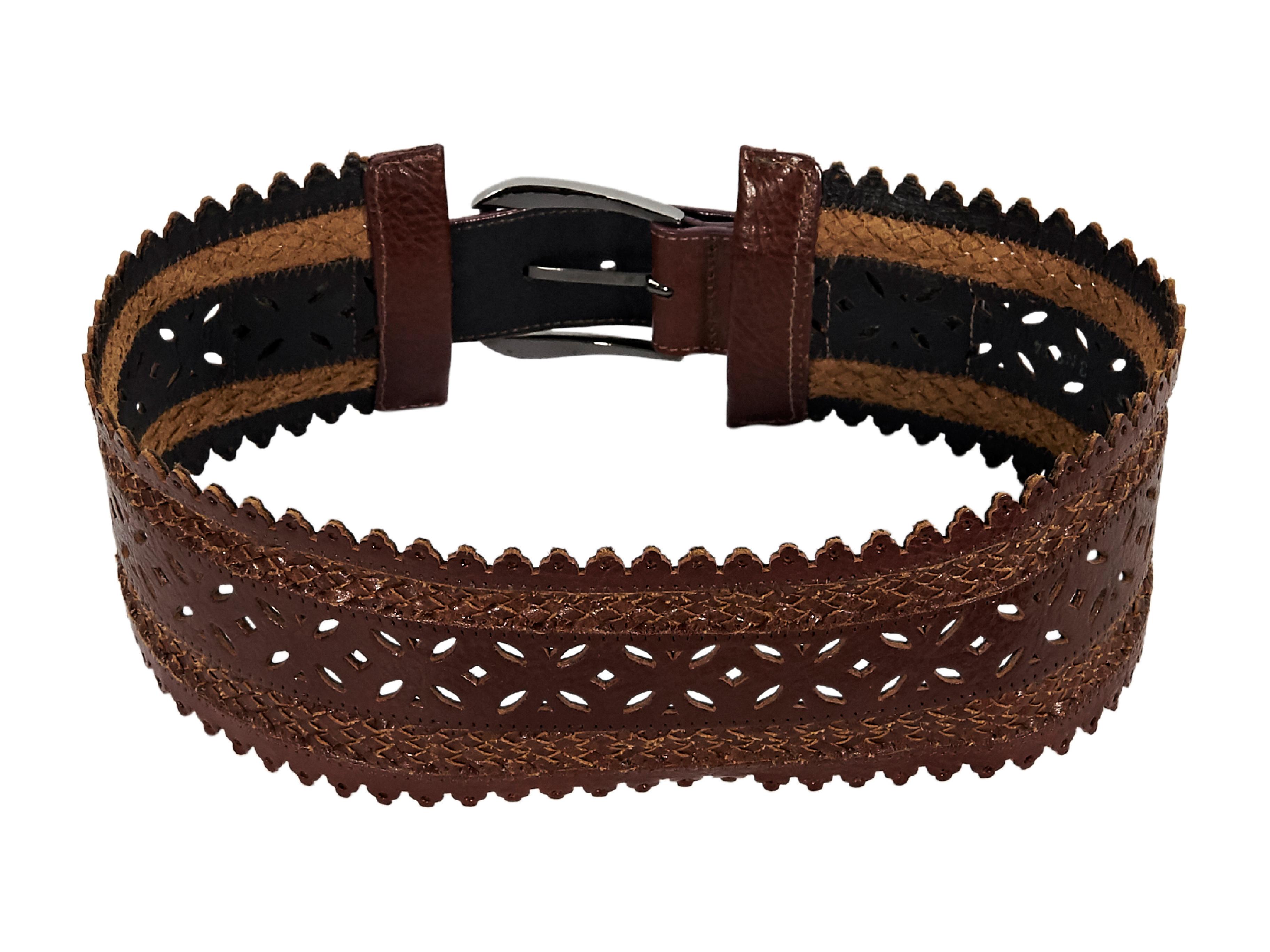 Product details:  Brown wide leather waist belt by Oscar de la Renta.  Features a laser-cut design.  Adjustable buckle closure.  Antiqued silvertone hardware.  26.5