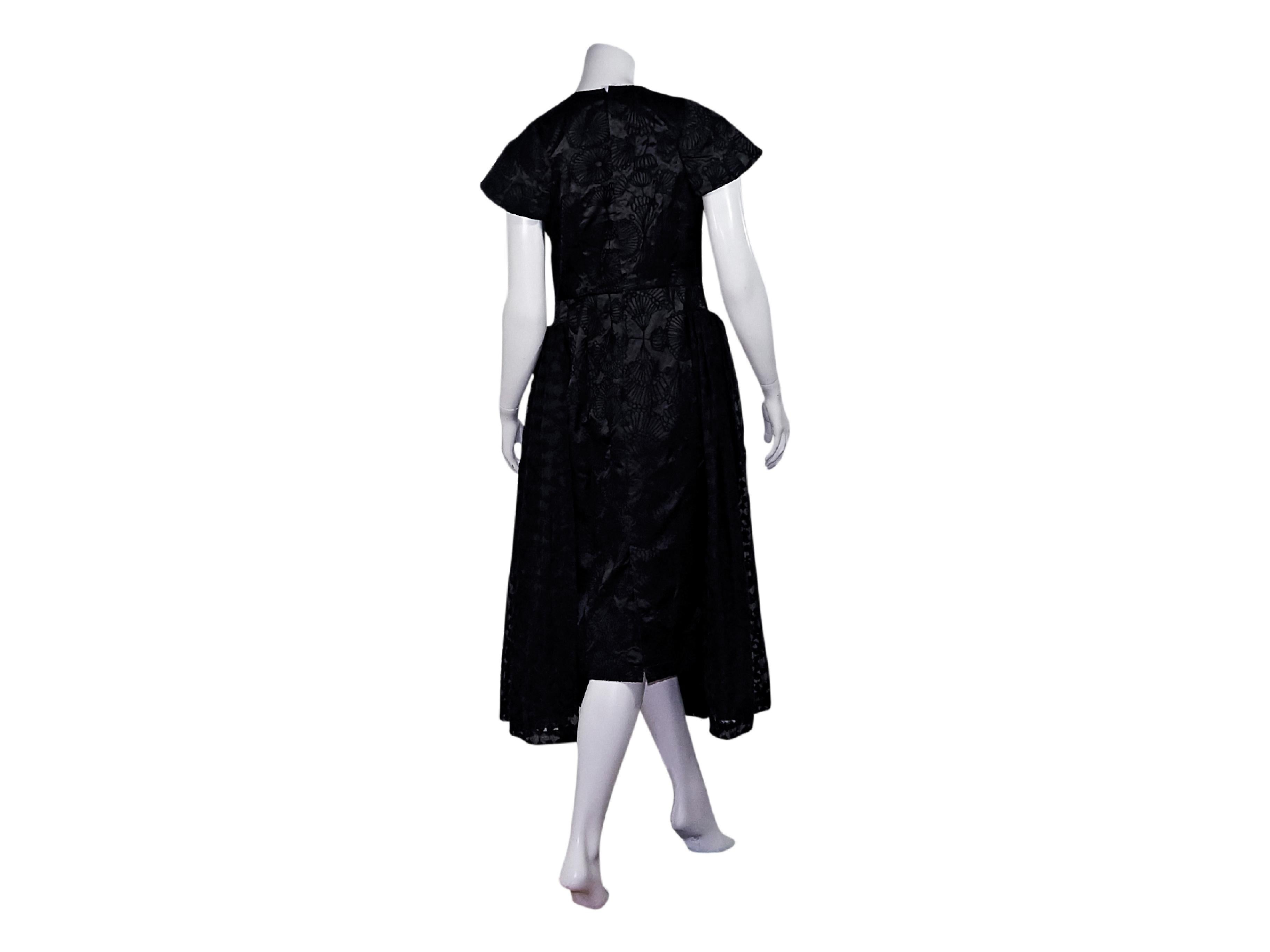 Product details:  Black embroidered evening dress by Comme des Garcons.  Crewneck.  Short dolman sleeves.  Concealed back zip closure.  Pleated skirting.  35