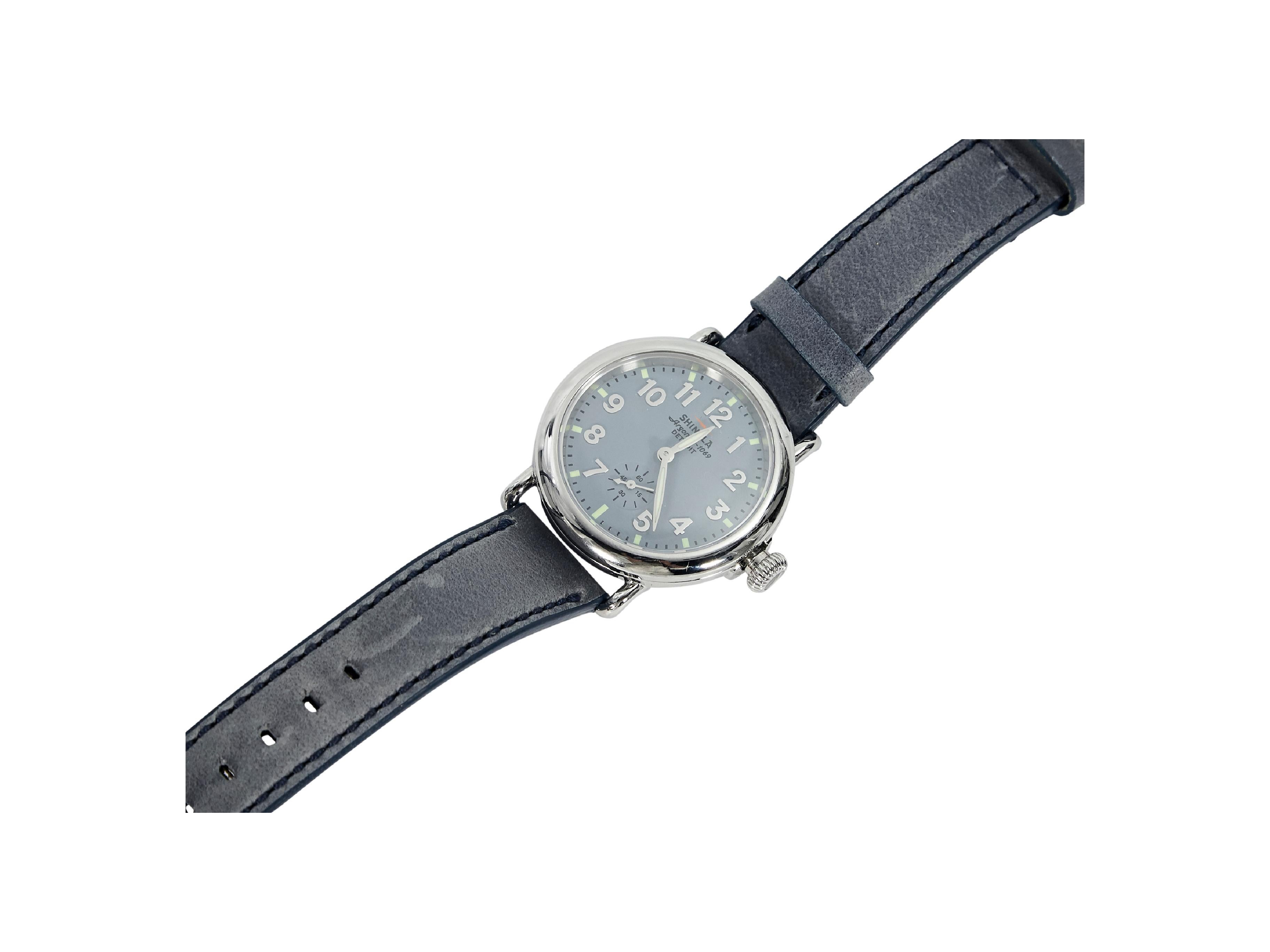 Product details:  Stainless steel and leather watch by Shinola.  Sapphire crystal.  Silvertone and luminous hour and minute hands and hour markers.  Stainless steel case.  Blue leather strap.  Adjustable buckle closure.  1.25