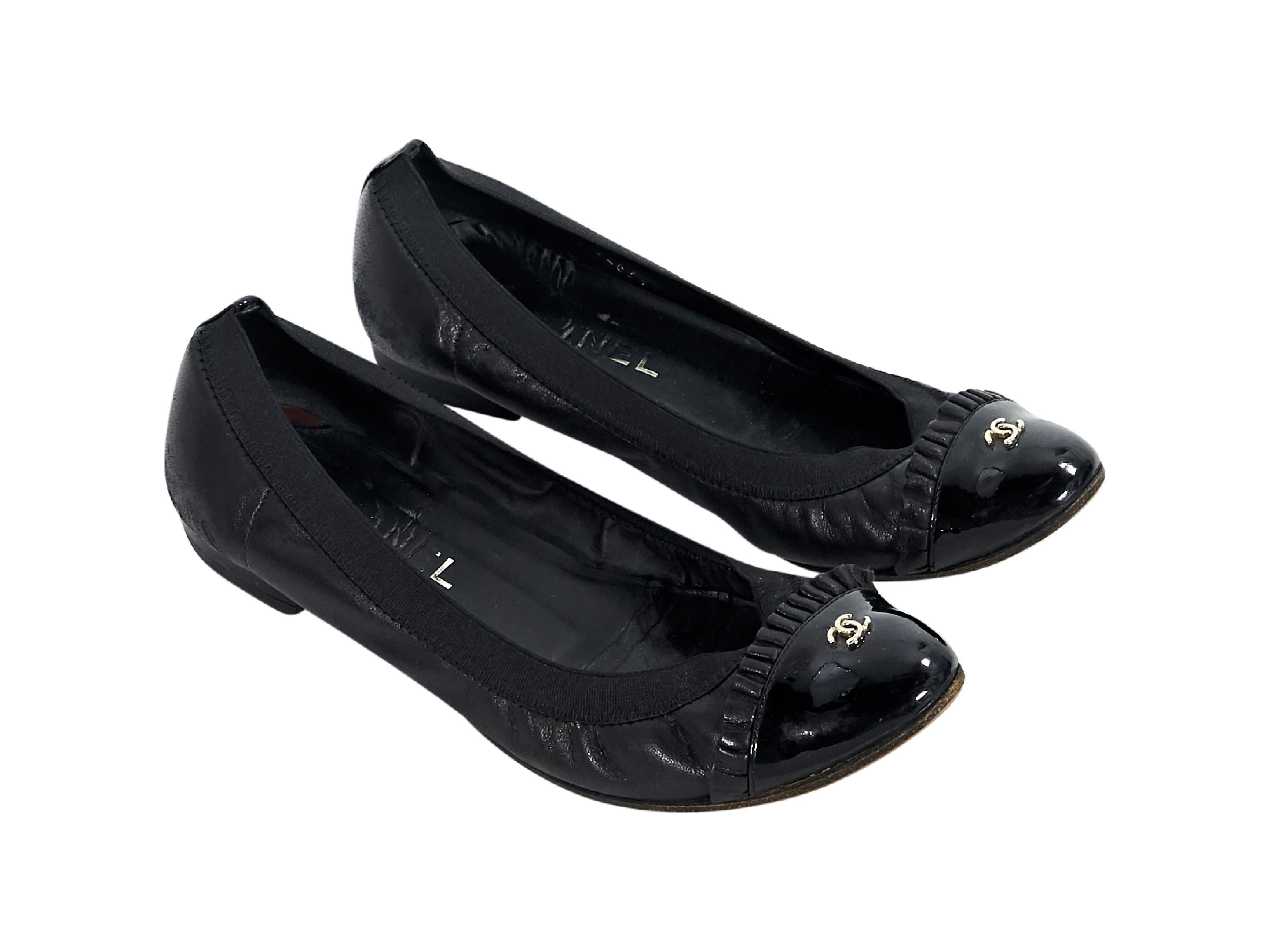 Product details:  Black leather ballet flats by Chanel.  Trimmed with patent leather.  Elasticized topline. Round cap toe with ruffle trim.  Slip-on style.  0.5