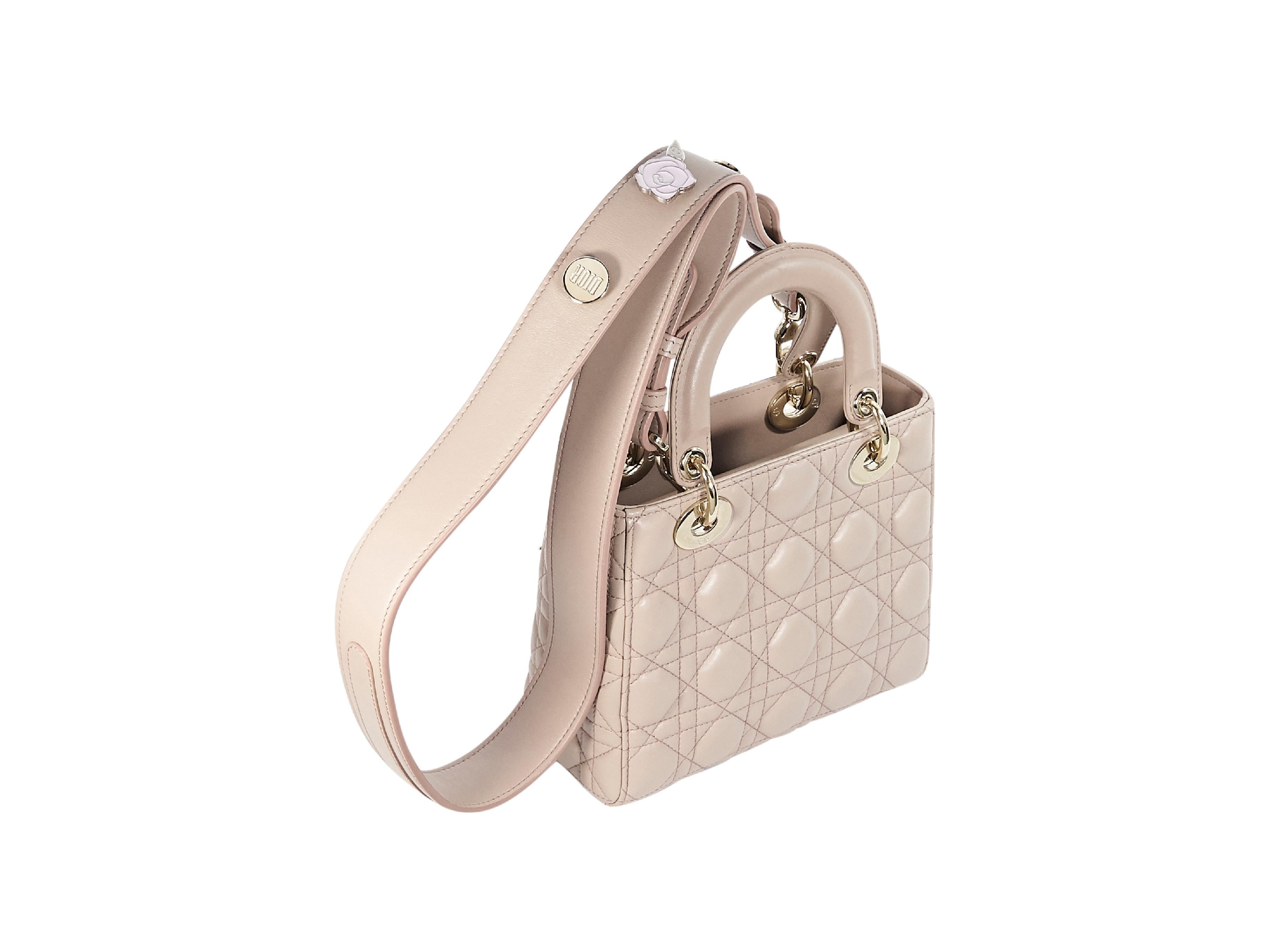 Product details:  Beige quilted leather Lady Dior mini satchel bag by Christian Dior.  Dual carry handles.  Detachable shoulder strap.  Top flap closure.  Lined interior with inner zip pocket.  Protective metal feet.  Goldtone hardware.  7.5