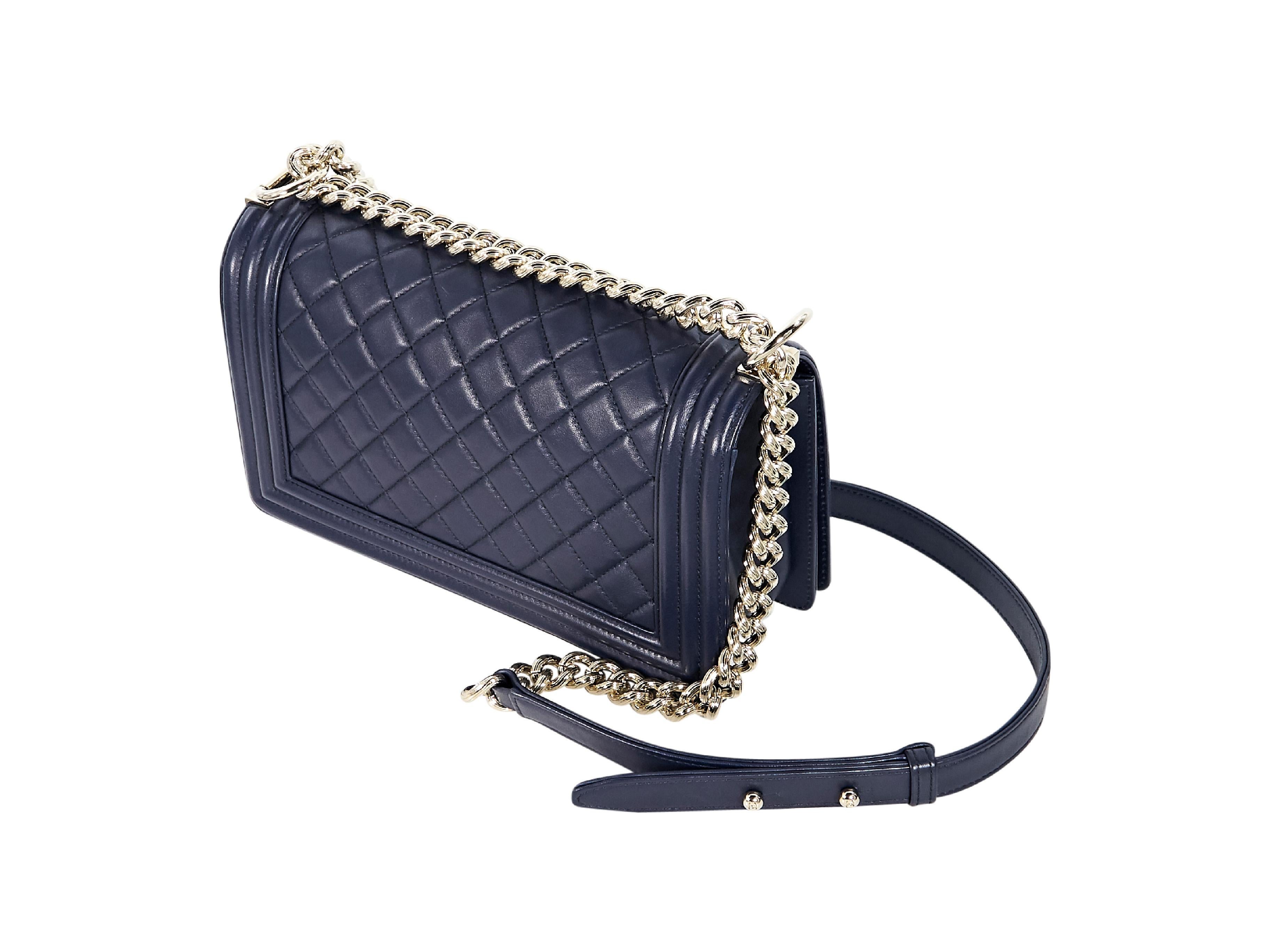 Product details:  Navy blue quilted leather Boy shoulder bag by Chanel.  Adjustable leather and chain shoulder strap.  Front flap with concealed closure.  Lined interior with inner slide pocket.  Goldtone hardware.  Authenticity card included.  10