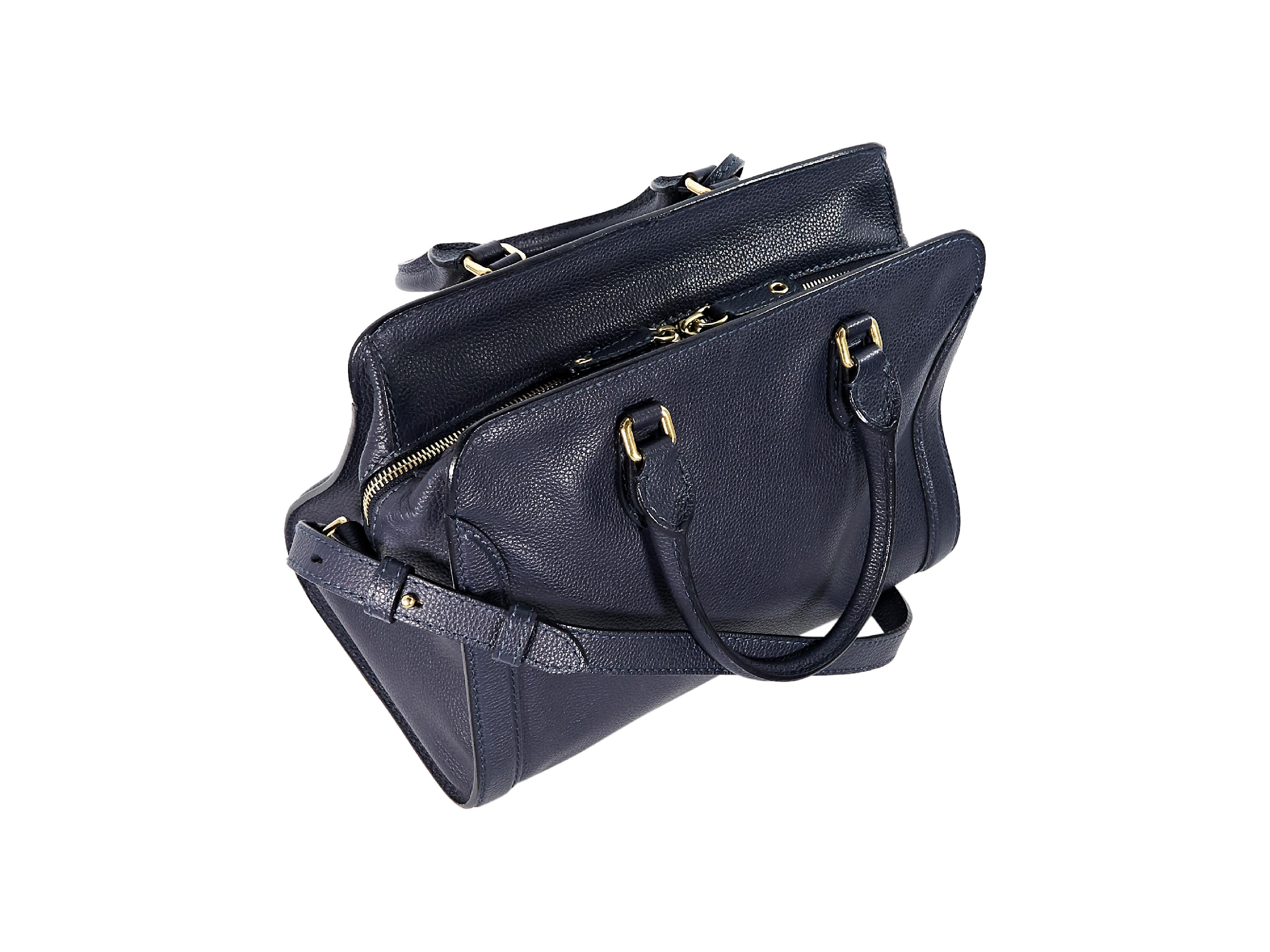 Product details:  Navy blue leather padlock satchel by Alexander McQueen.  Dual carry handles.  Detachable, adjustable crossbody strap.  Top zip closure.  Lined interior with inner zip and slide pockets.  Goldtone hardware.  12