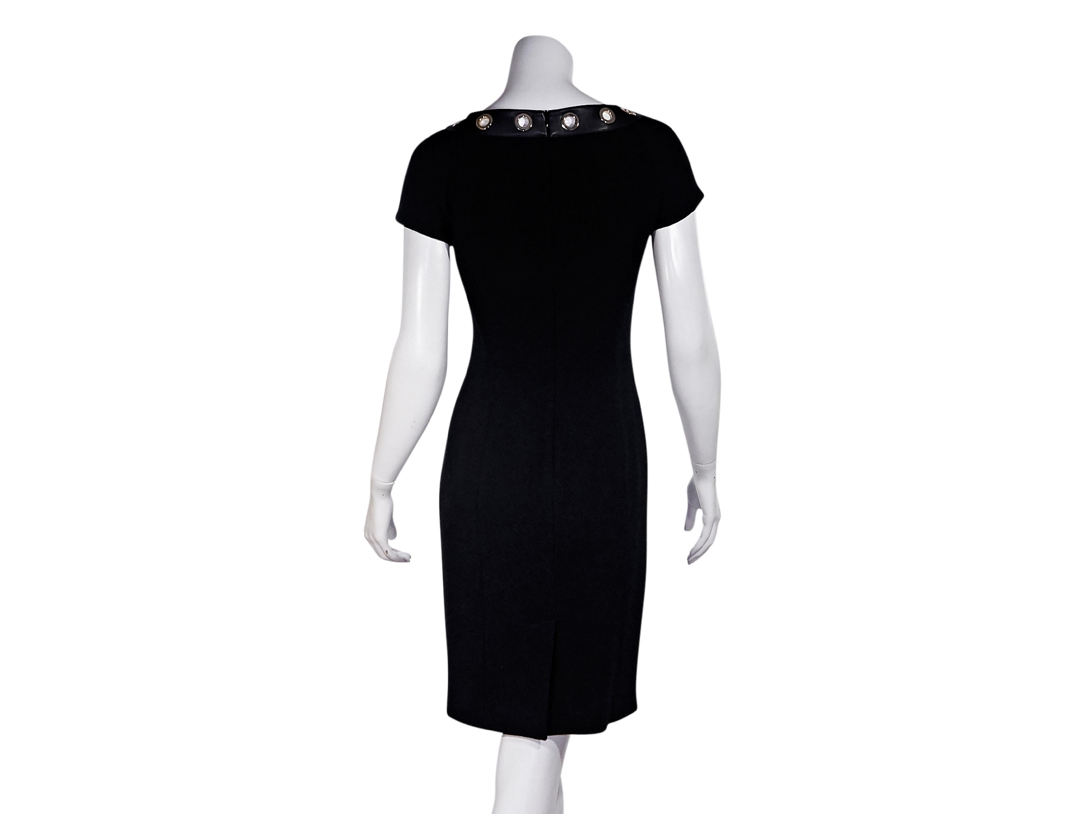 Product details:  Black sheath dress by Moschino Boutique.  Scoopneck accented with grommets.  Short sleeves.  Concealed back zip closure.  30