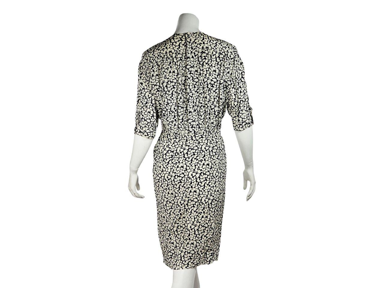 Product details:  Vintage navy blue and cream floral-printed silk tea dress by Valentino.  Circa the early 1990s.  Accented with pleats.  Jewelneck.  Elbow-length sleeves.  Concealed button-back closure.  43.5