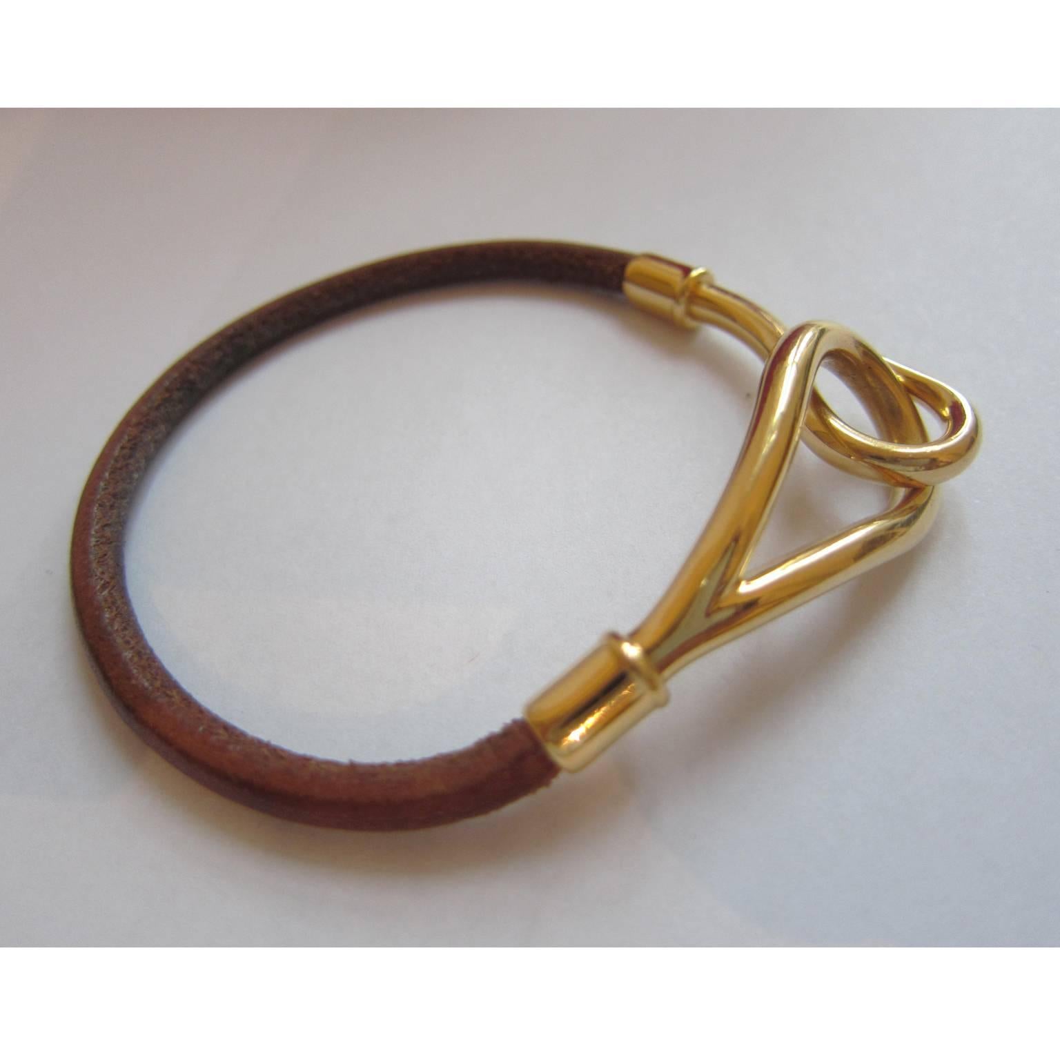 Hermes dark brown leather single wrap bracelet. Gold tone hardware hook closure, HERMES logo embossed. 

Total length : 18.5 cm

