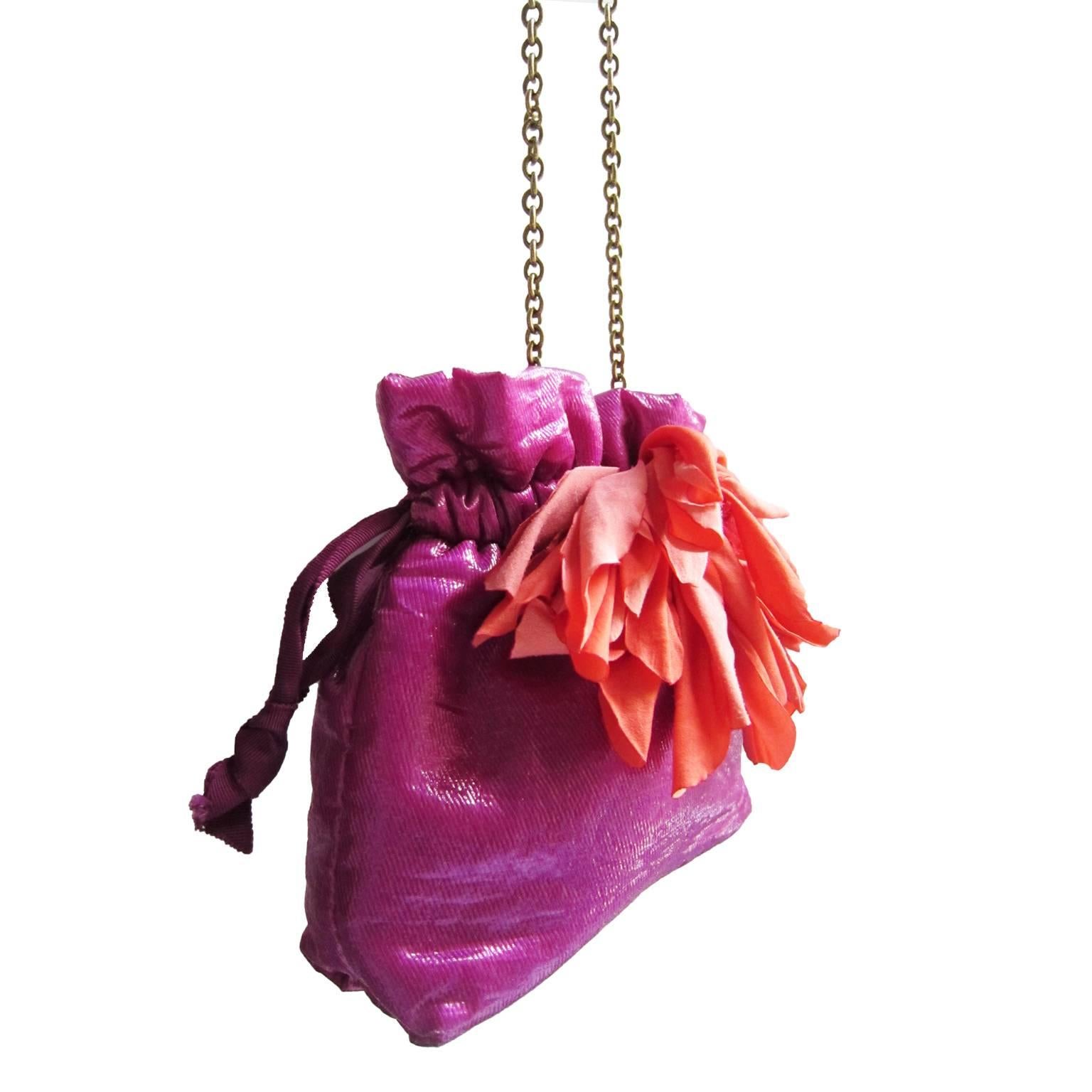 An eye-catching fuchsia palette Lanvin pouch with oversized bright orange flower detail. 
Could be used a clutch or over the shoulder with gold tone metal chain.
One interior pocket.
Made in Italy.
Measurements: : 
15 cm x 18.5 cm x 5 cm

