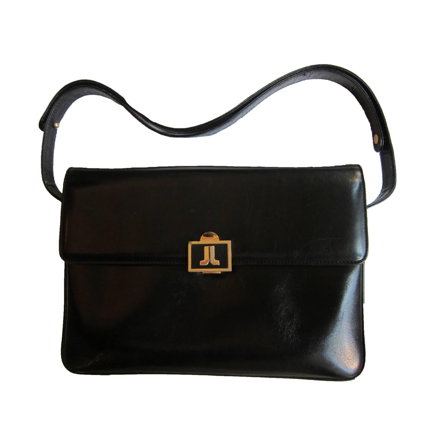 Lanvin vintage shoulder box bag in black leather. It has a beautifully crafted classic logo hard wear closure. 
Inside - divided in three compartments - the back compartment features a zipper side pocket, the middle compartment offers one with long
