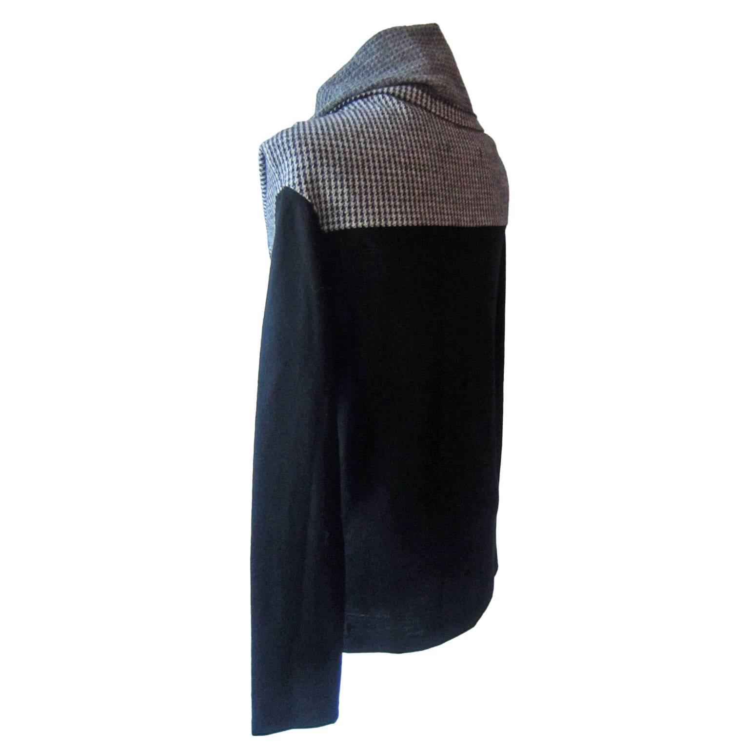 A black turtleneck jumper by Yohji Yamamoto. The jumper is produced in thin wool. It has a loose, fold down turtleneck in light cream and black contrast Pied De Poule pattern fabric. The fabric is soft, and will fall nicely on the