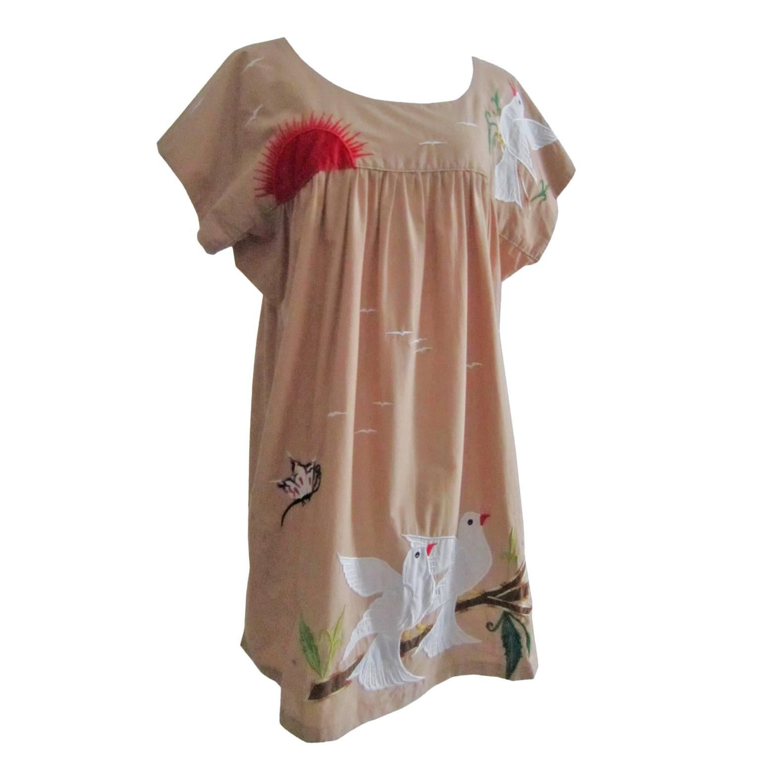 Vintage Oaxacan embroidered dress from circa 1970s.
A-Line silhouette taupe pink / beige cotton base with bright white birds appliques and embroidered butterfly, flower motifs. A lovely happy dress.
 
Measurements : 
Shoulders : circa 38 cm
Underarm