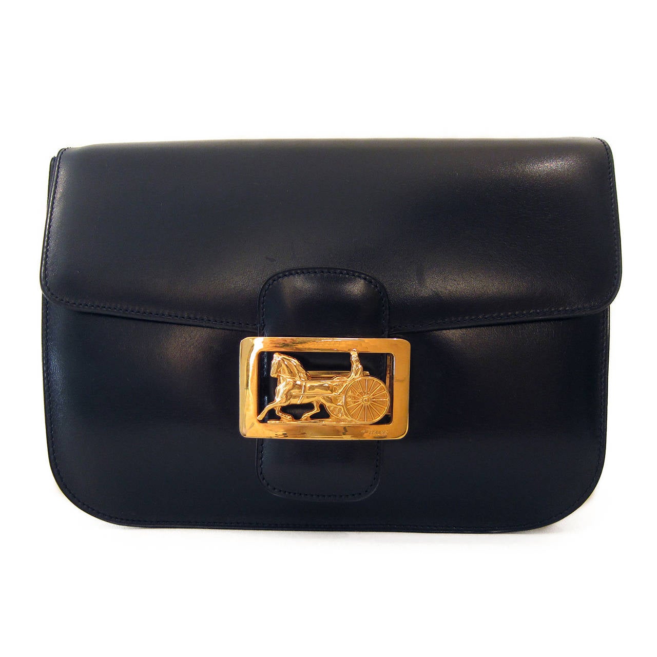 Céline Diffusion vintage shoulder box bag in very dark navy (closer to black) leather. It has a beautifully crafted classic golden horse carriage closure. 
Inside - divided in three compartments - the back compartment features a zipper side pocket
