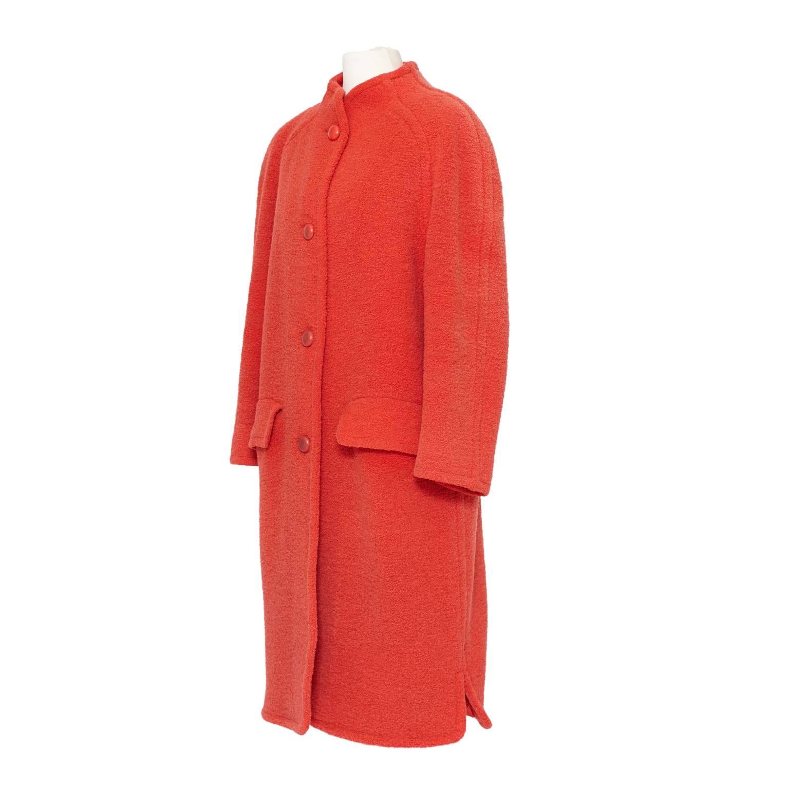 Courreges iconic orange red coat from 1970's. Constructed raglan sleeve alpaca coat featuring sewn in flap pockets with center front button closure, fully lined. Rounded rectangle hem front and sides with cover stitches.
Made in France. 
Original