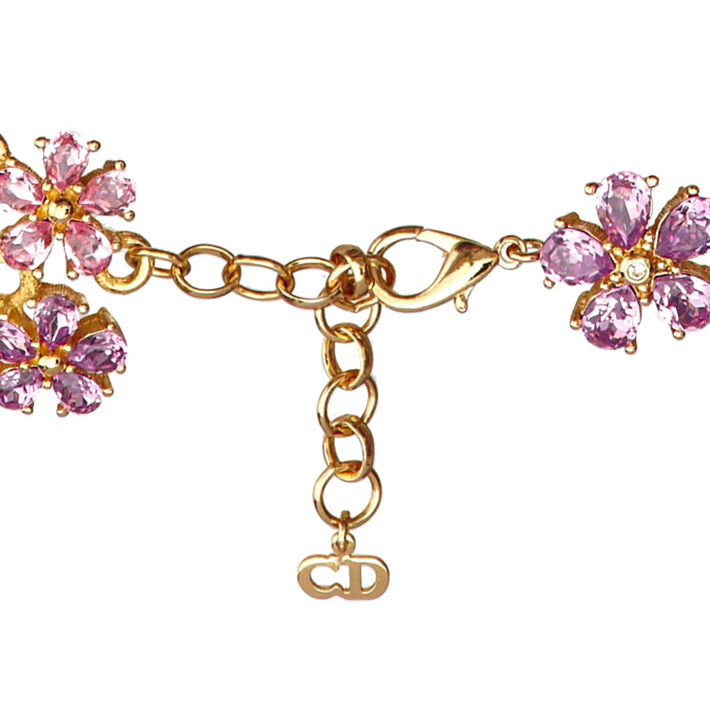 Stunning feminine floral necklace by the House of Dior, made up of Pink and Purple teardrop rhinestones which form clusters of flowers, set in heavily plated gold tone metal, c.1980′s

The larger flowers measure approx 2cm x 2cm and the smaller