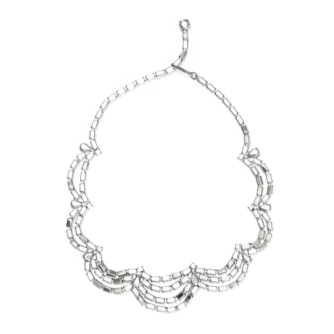 Lovely Rhodium plated graduated swag design necklace made up of clear crystal baguette rhinestones by Kramer of New York.

The necklace is 39cm or 15 inches long, and can be adjusted to be made smaller, the longest drop from the necklace is