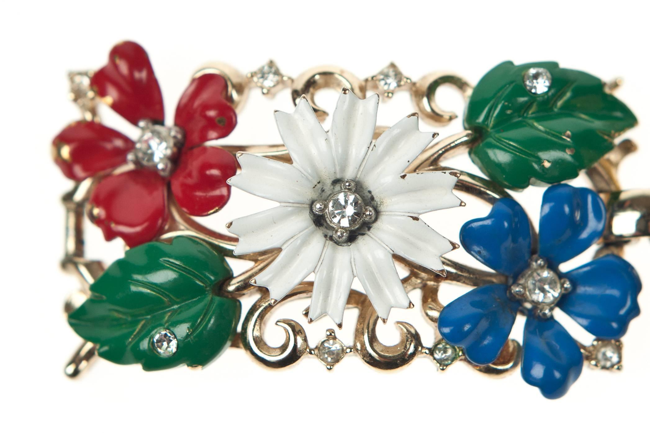 Beautiful bright primary coloured enamelled floral bracelet by Trifari, part of their “Field of Flowers” range c.1956.
The wide goldtone bracelet is composed for four articulated panels each embellished with indivdually hand enamelled flowers and