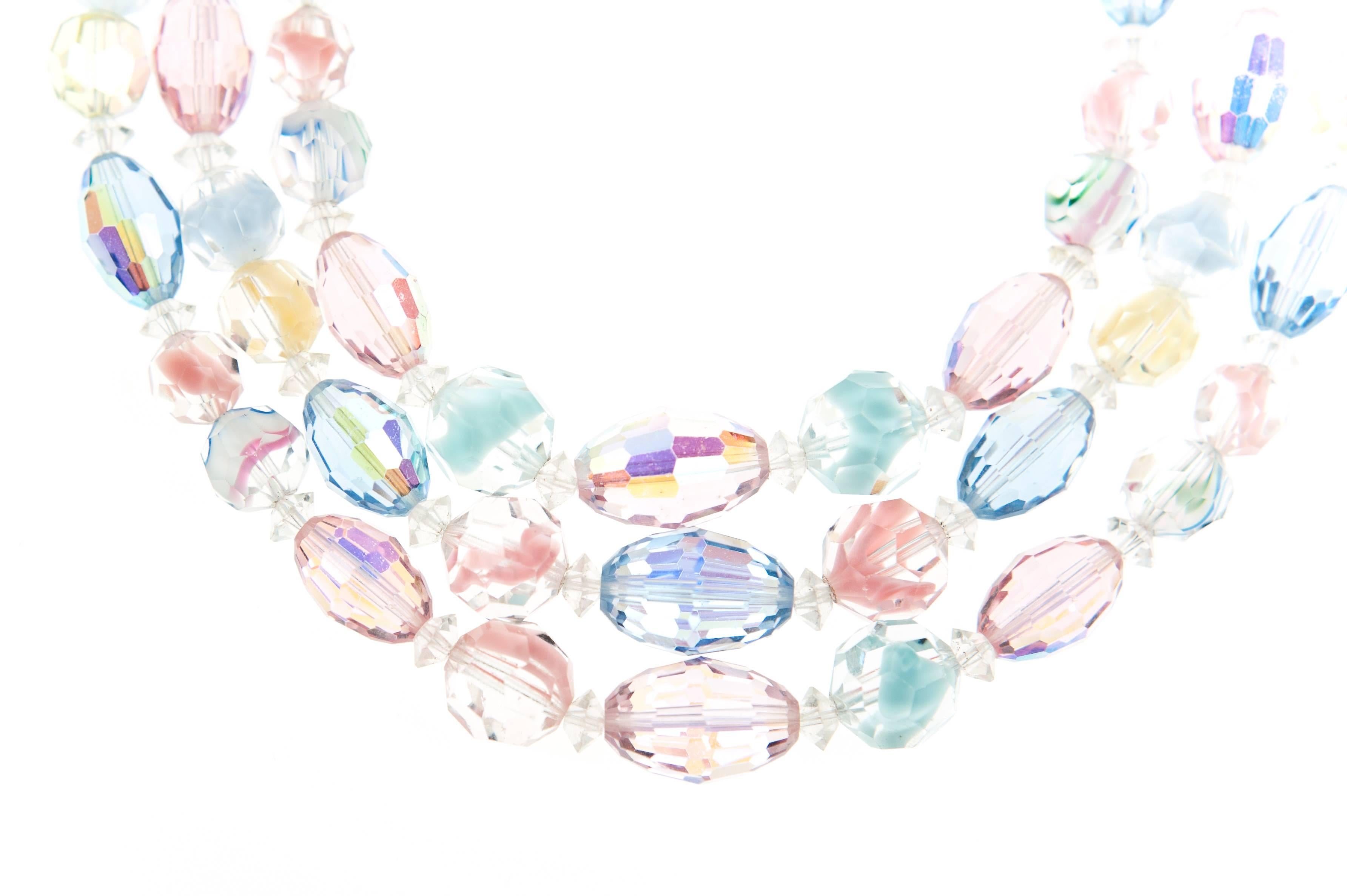 An exquisite triple strand Art glass necklace and matching clip on earrings by Laguna, c.1958.

The necklace is gorgeous graduated combination of Pink, Blue, Yellow Swarovski crystals with Aurora Borealis coasting and rare Givre beads, with