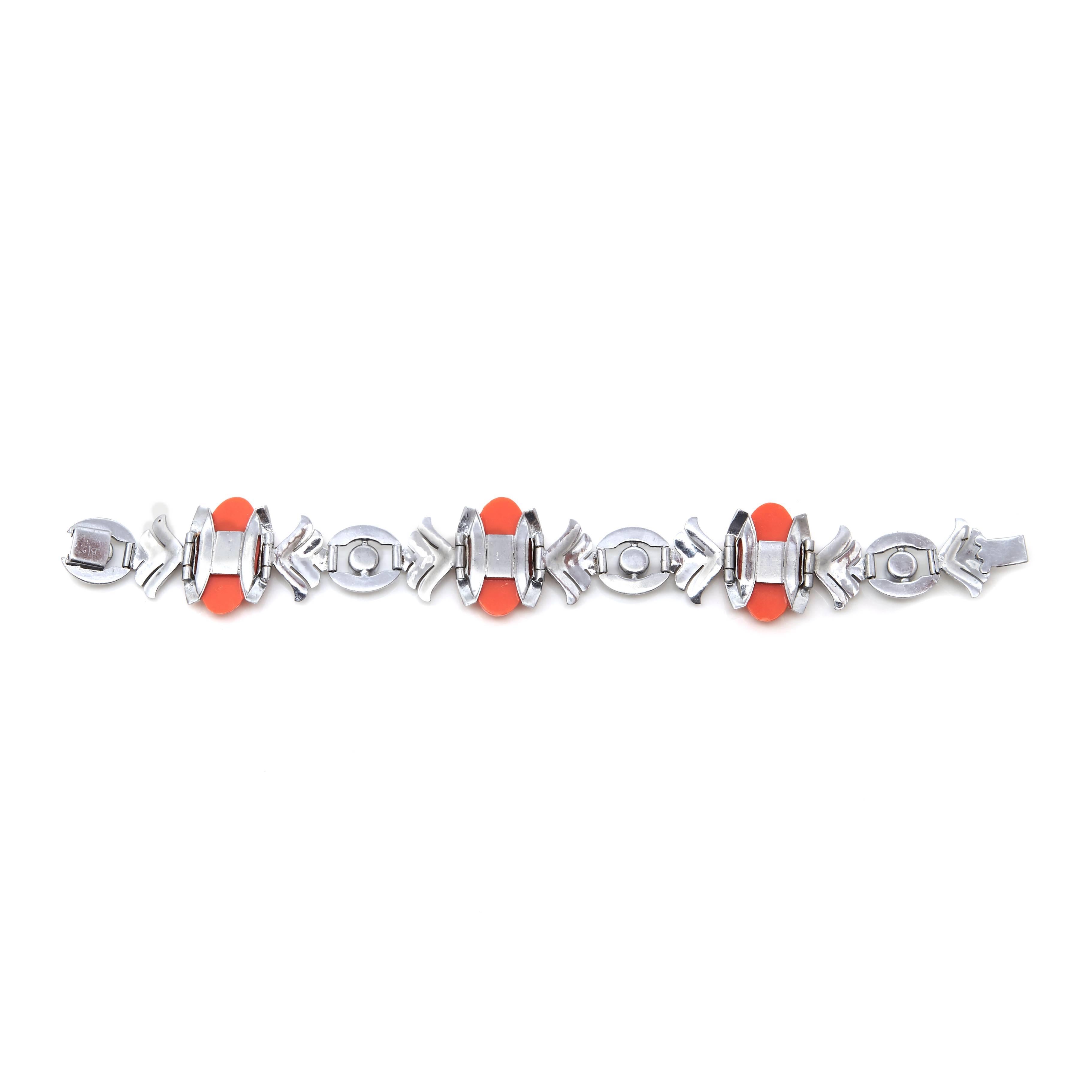 A stunning example of French Art Deco costume jewellery. This bracelet is white metal and is designed around three oval shaped moulded glass stones, each depicting Daises and Lily of the Valley, designed to imitate Coral. The rest of the bracelet is