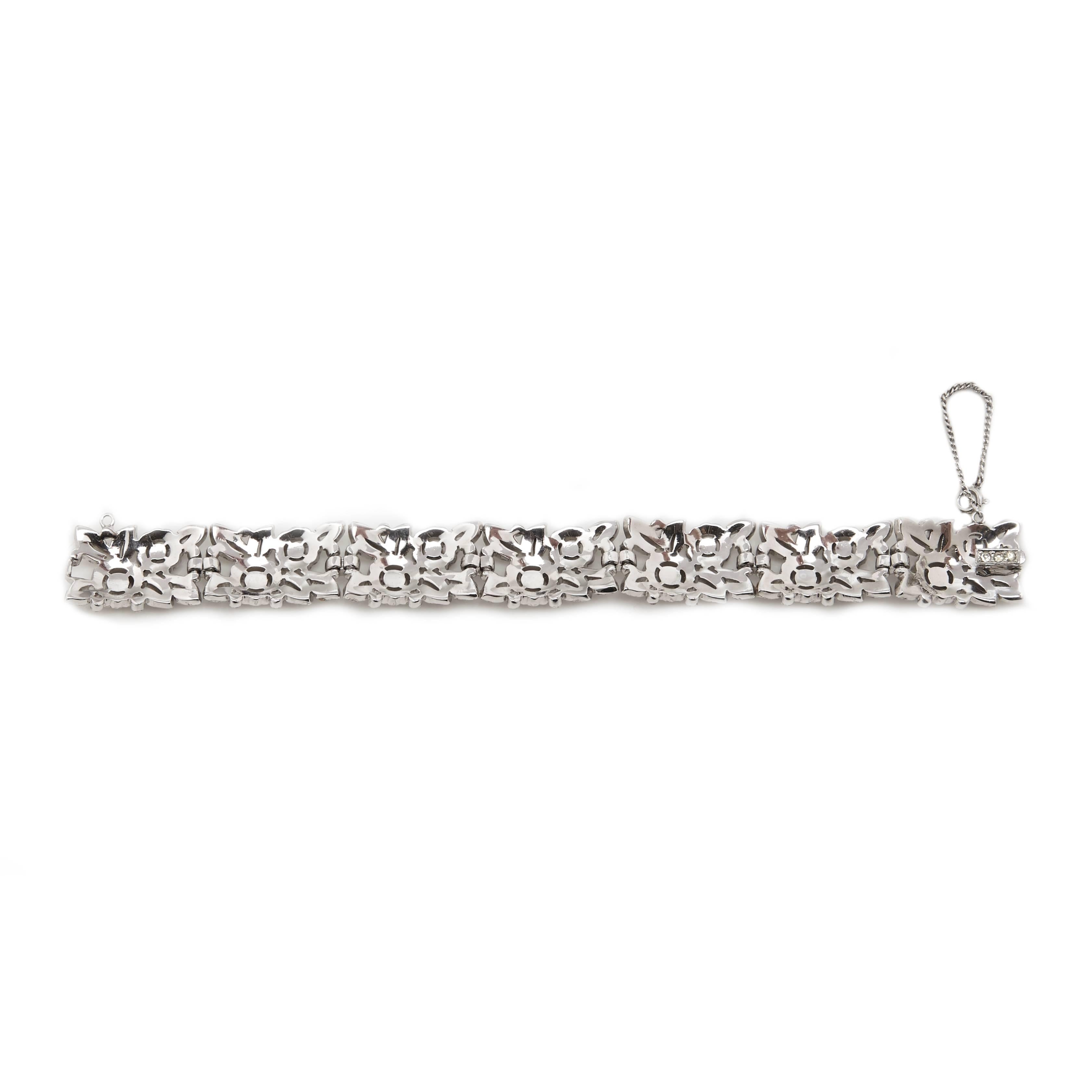A stunning rhodium plated silver tone bracelet by Trifari.

The delicate open-work design is of flowers and foliage, it is made up of 7 articulated panels, each leaf is embellished with crystal rhinestones and two sizes of blooming flowers. It comes