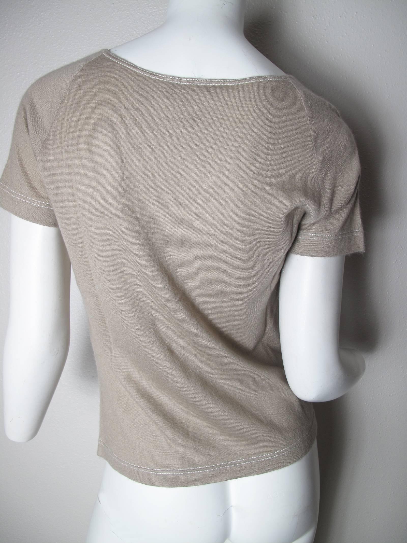 Chanel beige cashmere/ silk "t-shirt" short sleeve with white stitching at neck, bottom and sleeves.  Circa 2000. Condition: Excellent. Size 40

We accept returns for refund, please see our terms.  We offer free ground shipping within